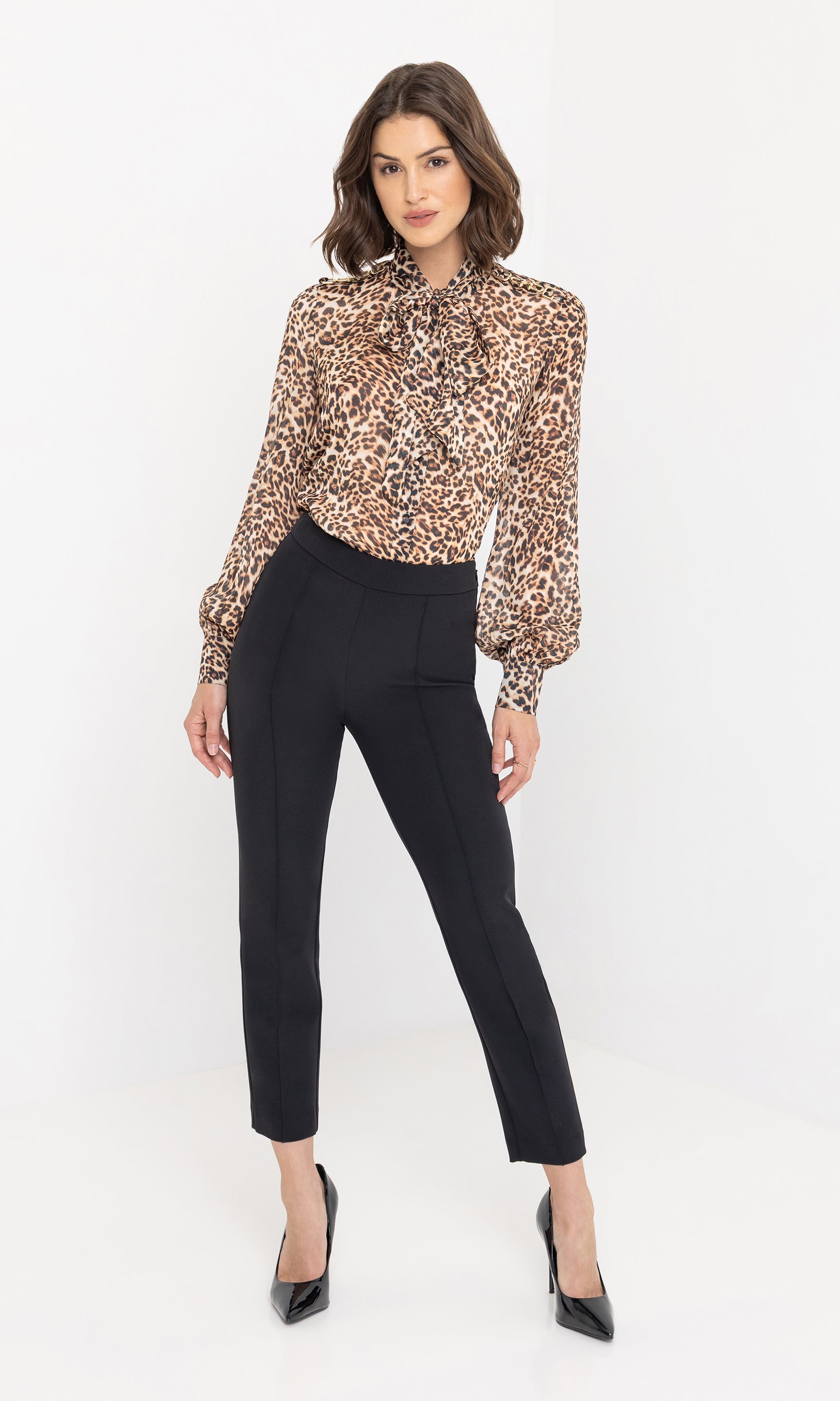 Full-length studio shot of the model wearing the Veralli Leo Blouse with slim black trousers, highlighting the blouse’s relaxed yet refined silhouette.