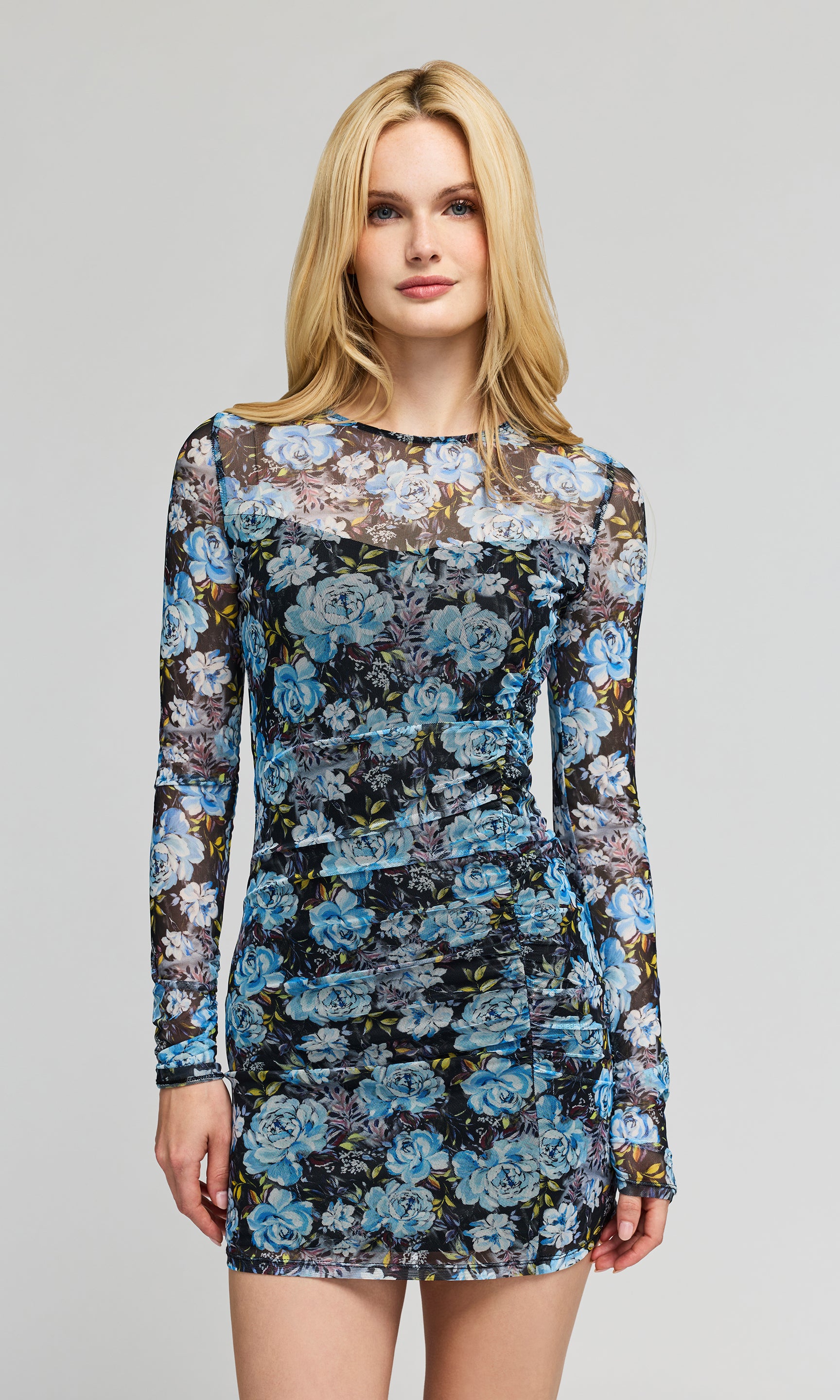 Woman wearing a floral mini dress on a gray background
