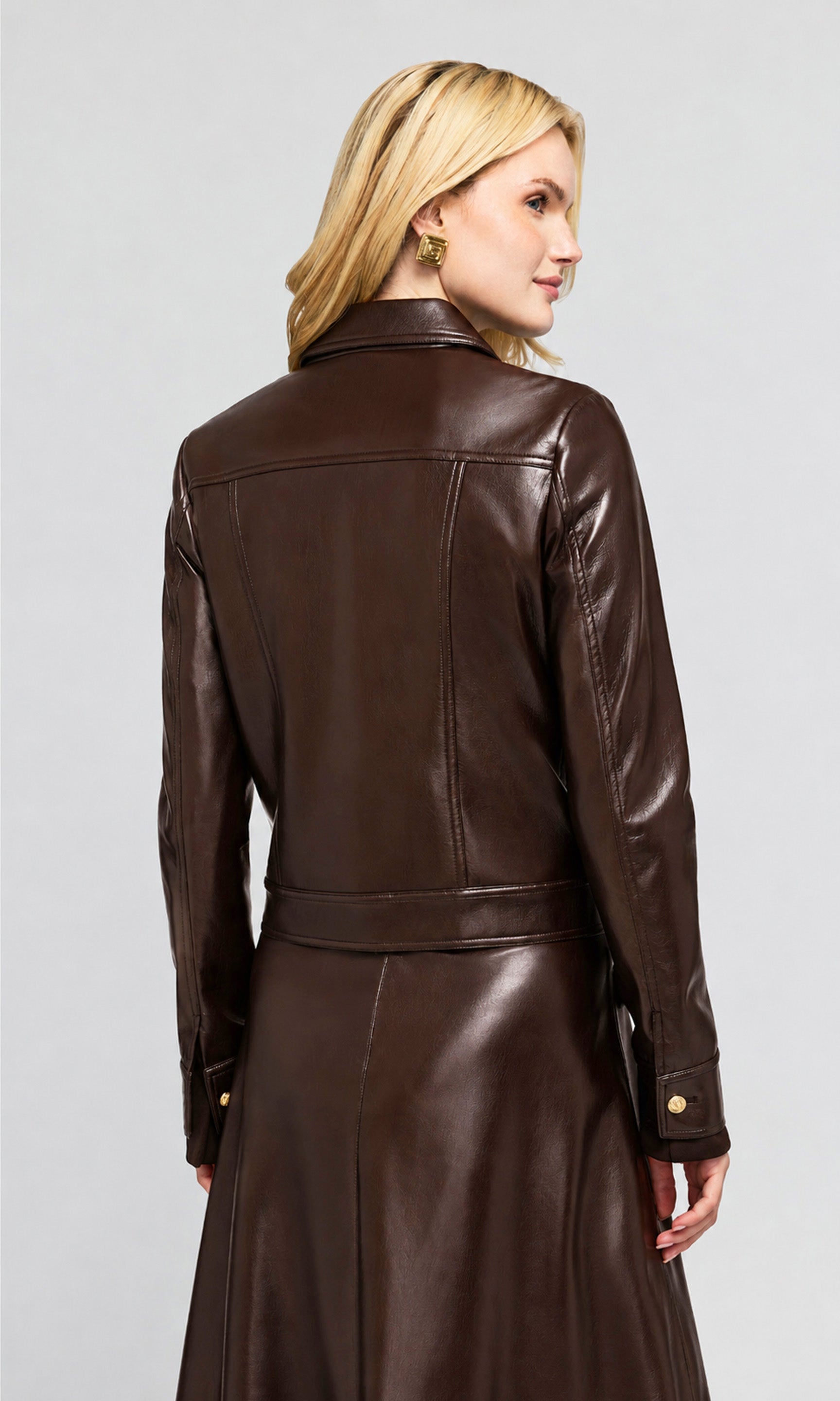 Back view of model wearing a dark brown faux-leather jacket with gold-tone buttons, on a plain background.