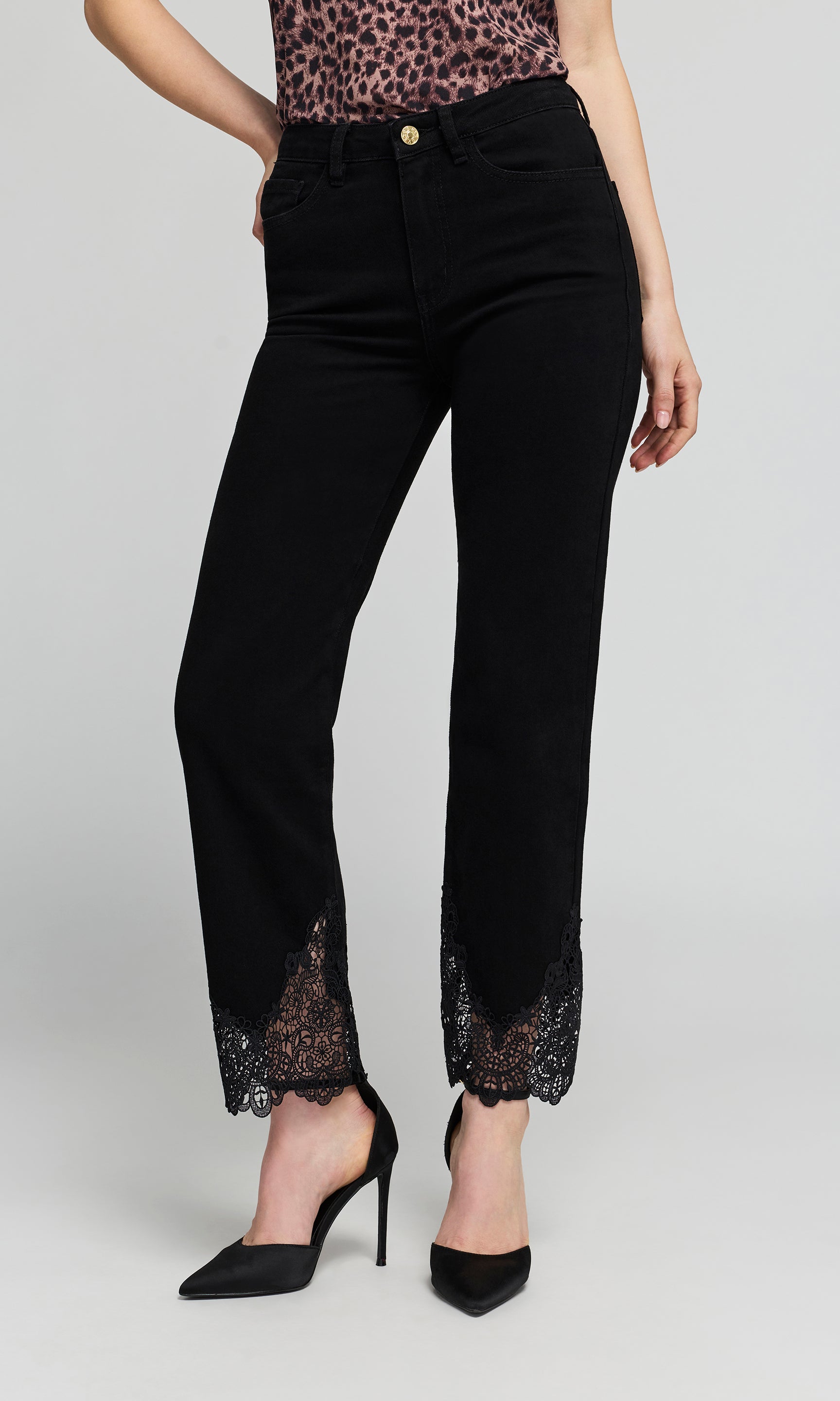 Black high-waisted ankle-length jeans with black lace trim at the hem, shown on a model wearing black pointed-toe.