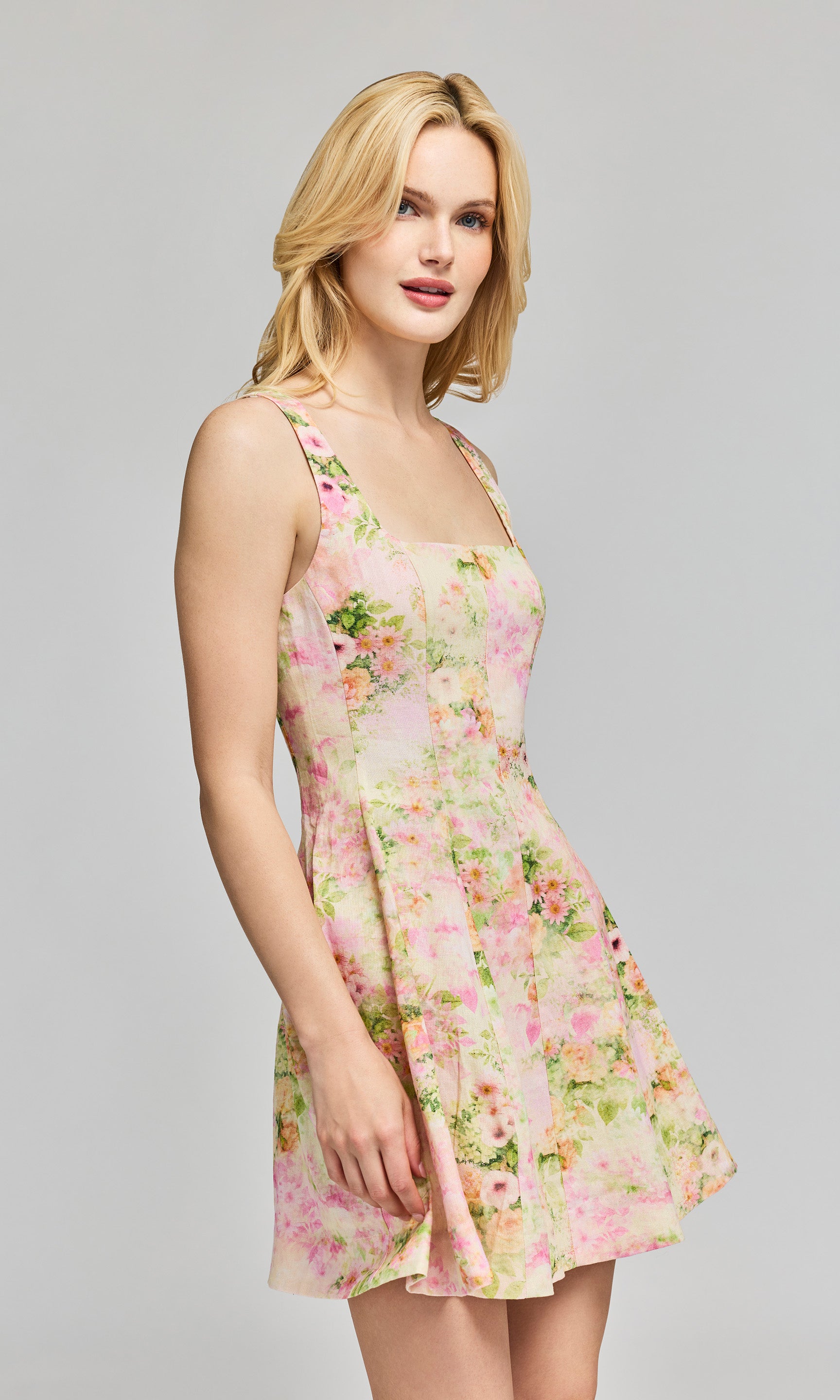 Side view of woman wearing a floral dress on a gray background