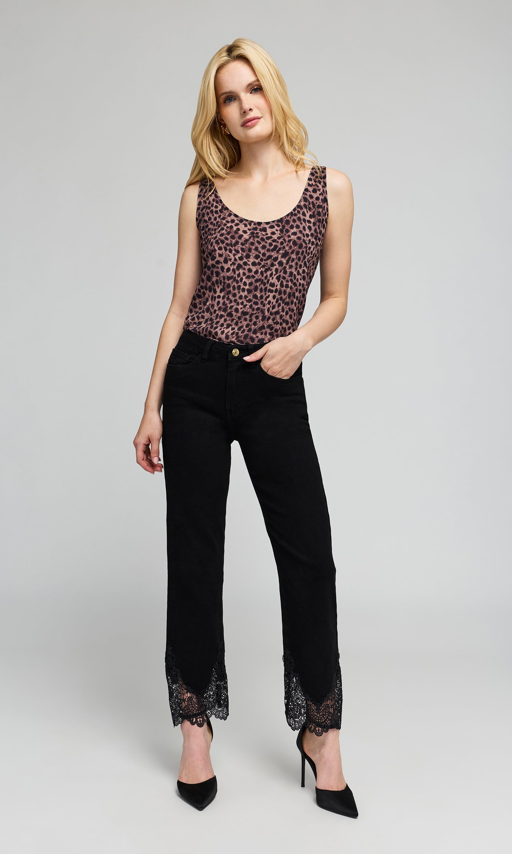 A blonde model wearing a leopard-print tank and black cropped pants with lace trim at the hem, on a plain background.