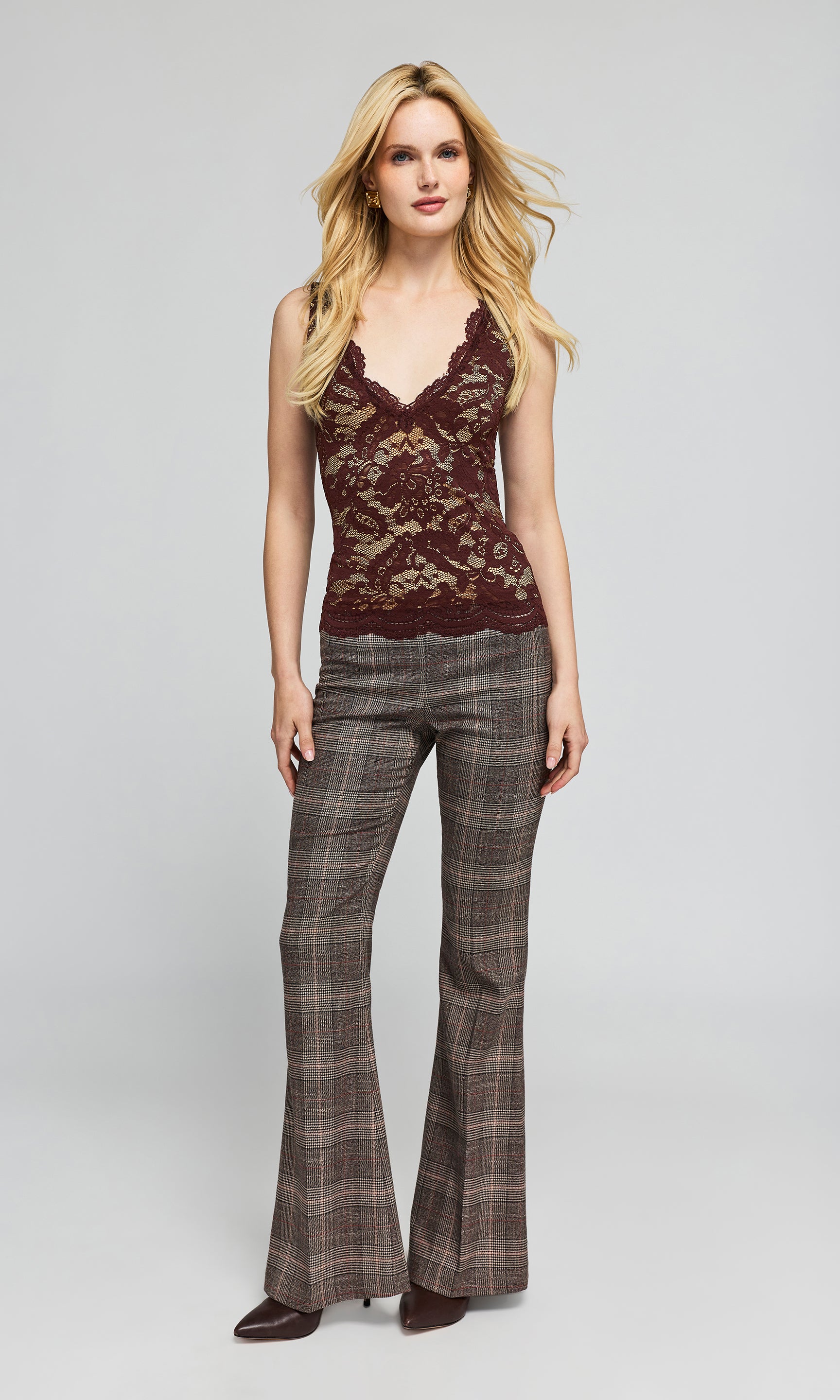 Model wearing a brown and beige lace tank paired with a brown plaid trouser, standing in front of a plain background.