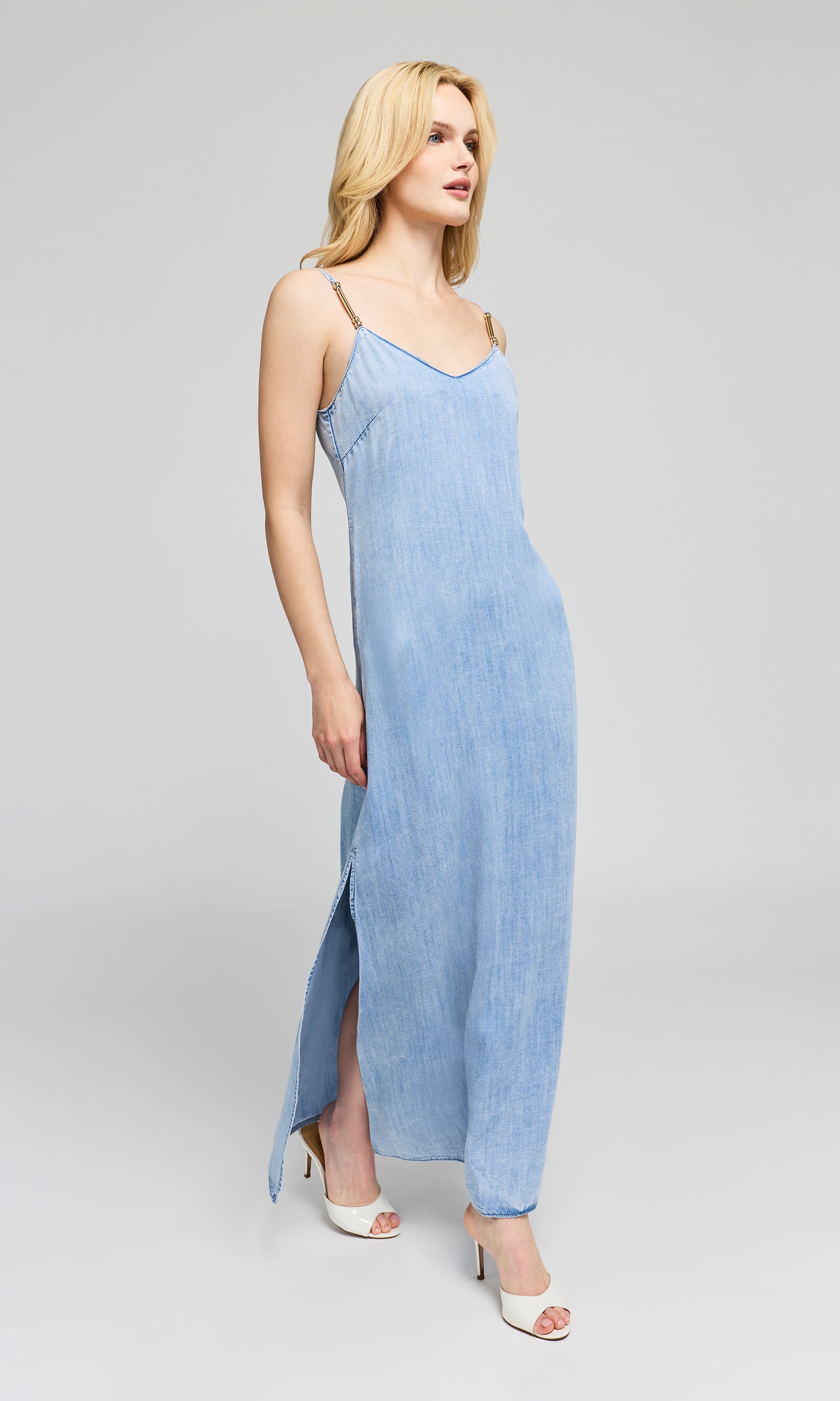 Side view of woman wearing a light blue dress on a gray background