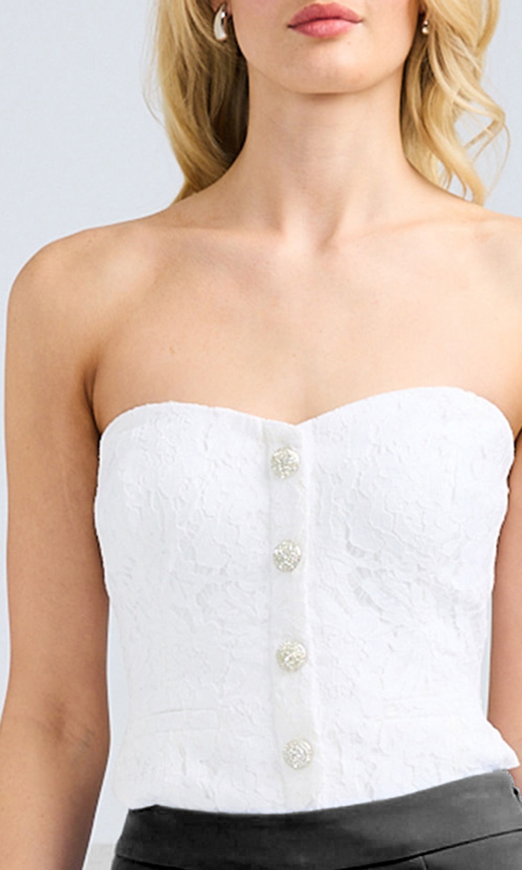 image of model wearing the Arianna vestier top showcasing the lace details and crystal buttons down the front