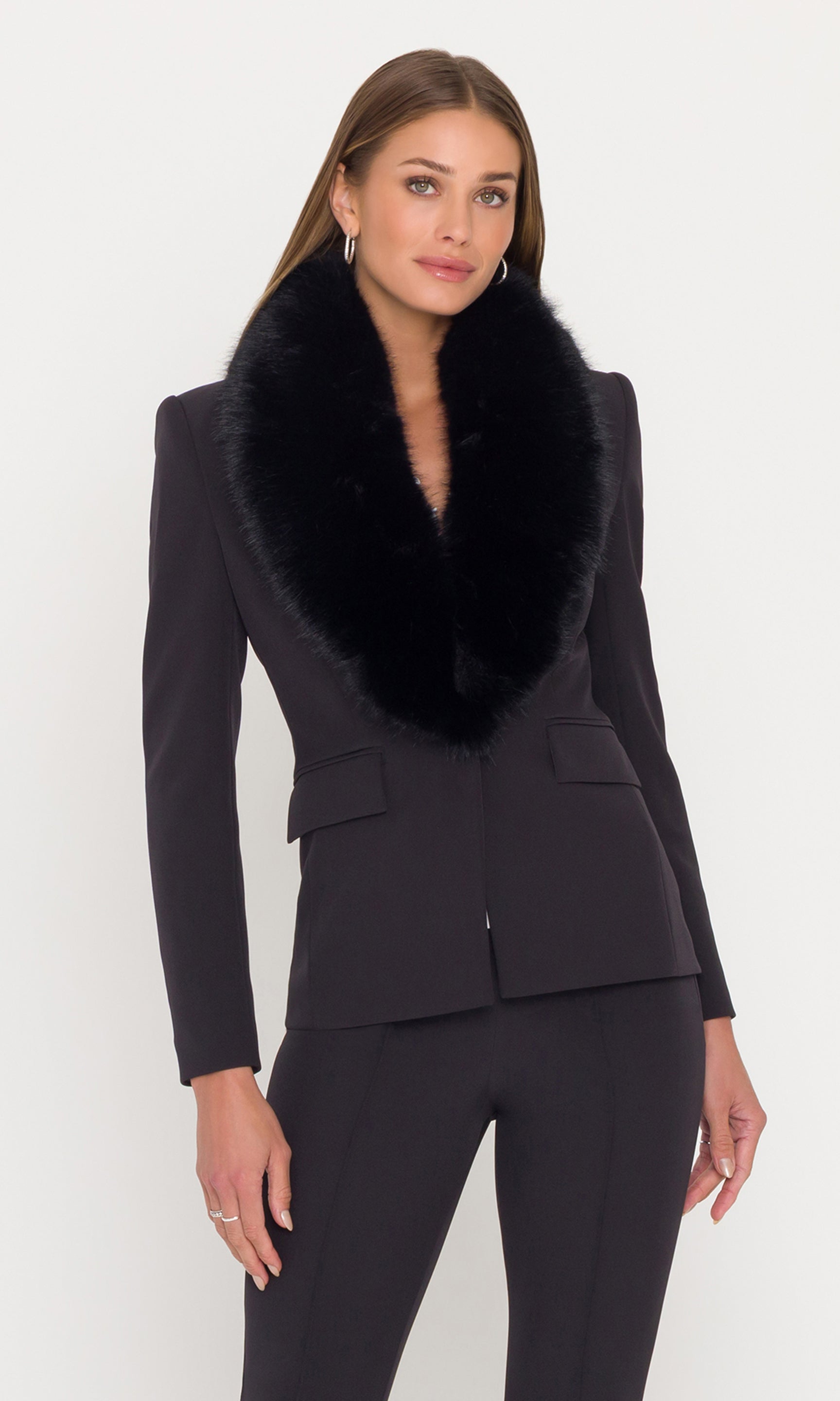Image of model wearing a black crepe blazer with a fur collar and black pants