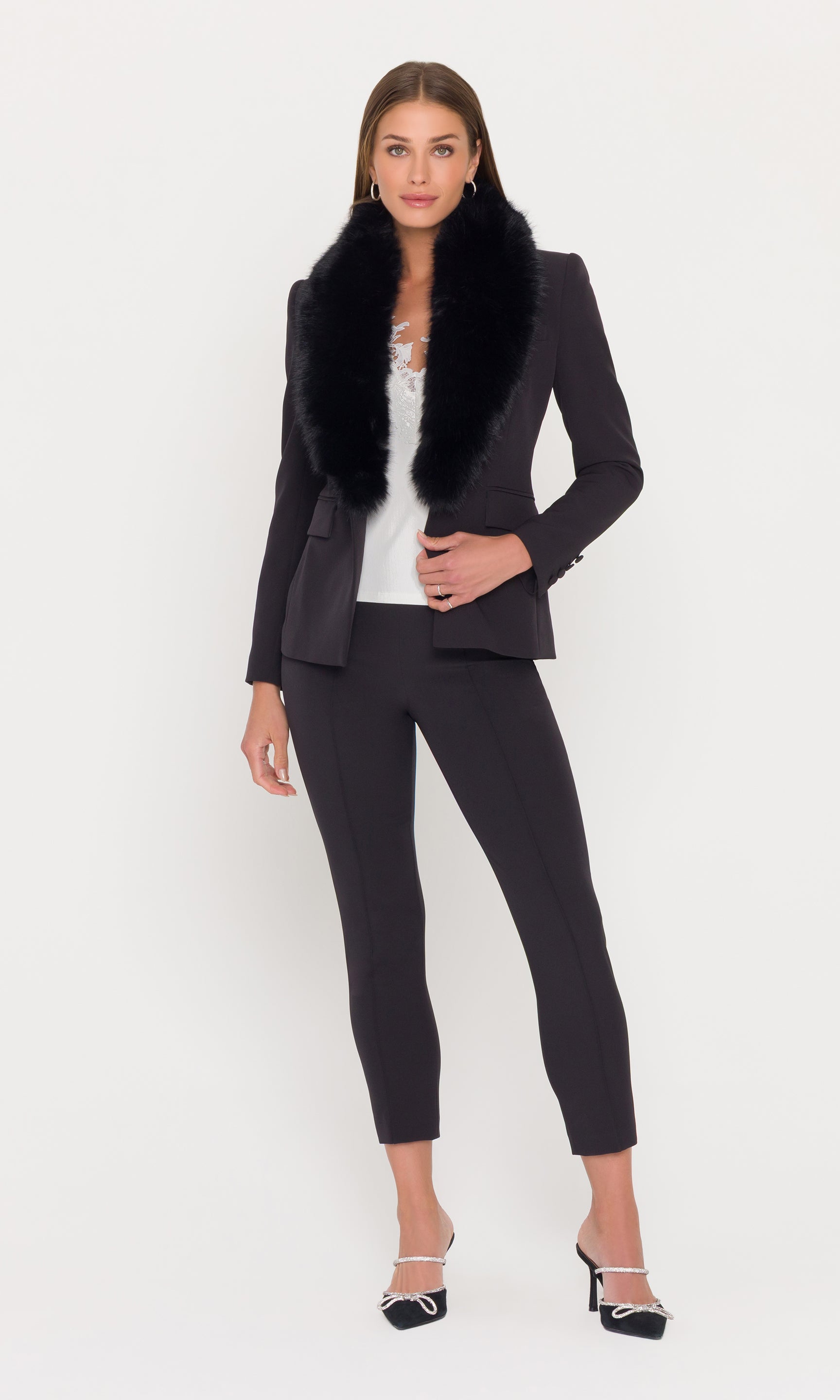 Full body image of model wearing a black crepe blazer with a fur collar and black pants