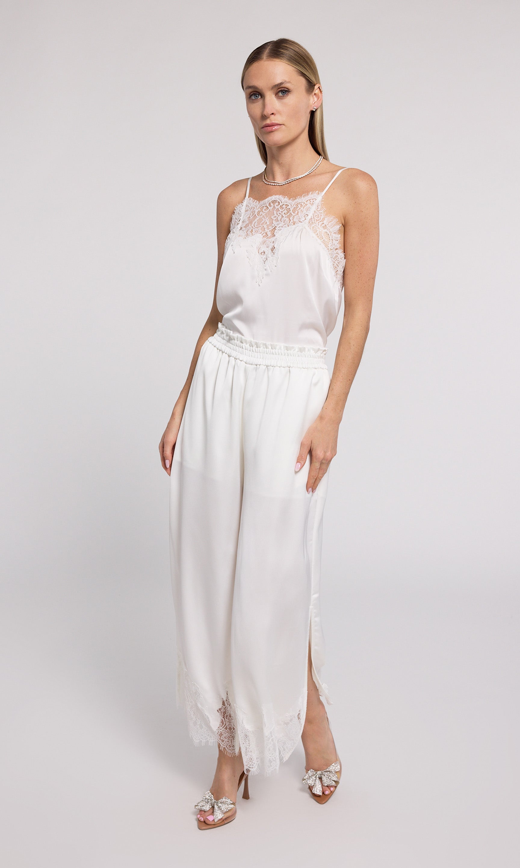 Stylish white wide-leg pants with delicate lace trim, perfect for adding a touch of elegance to your outfit.