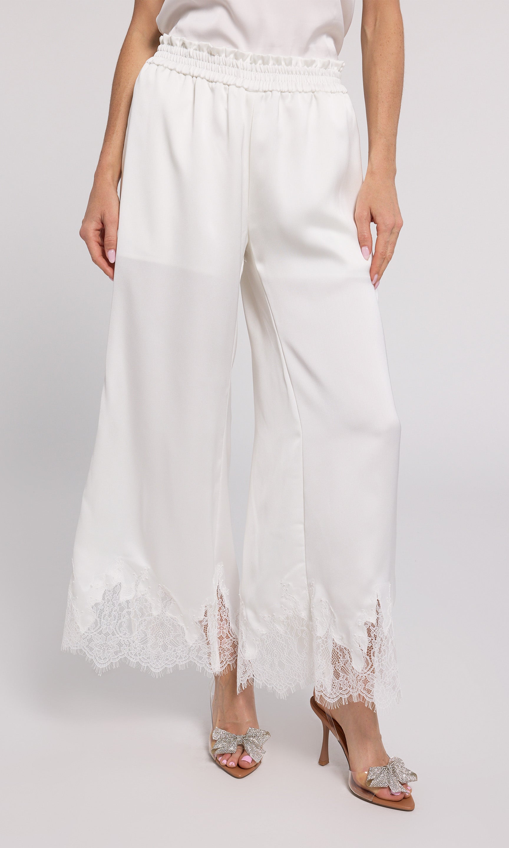 Stylish white wide-leg pants with delicate lace trim, perfect for adding a touch of elegance to your outfit.