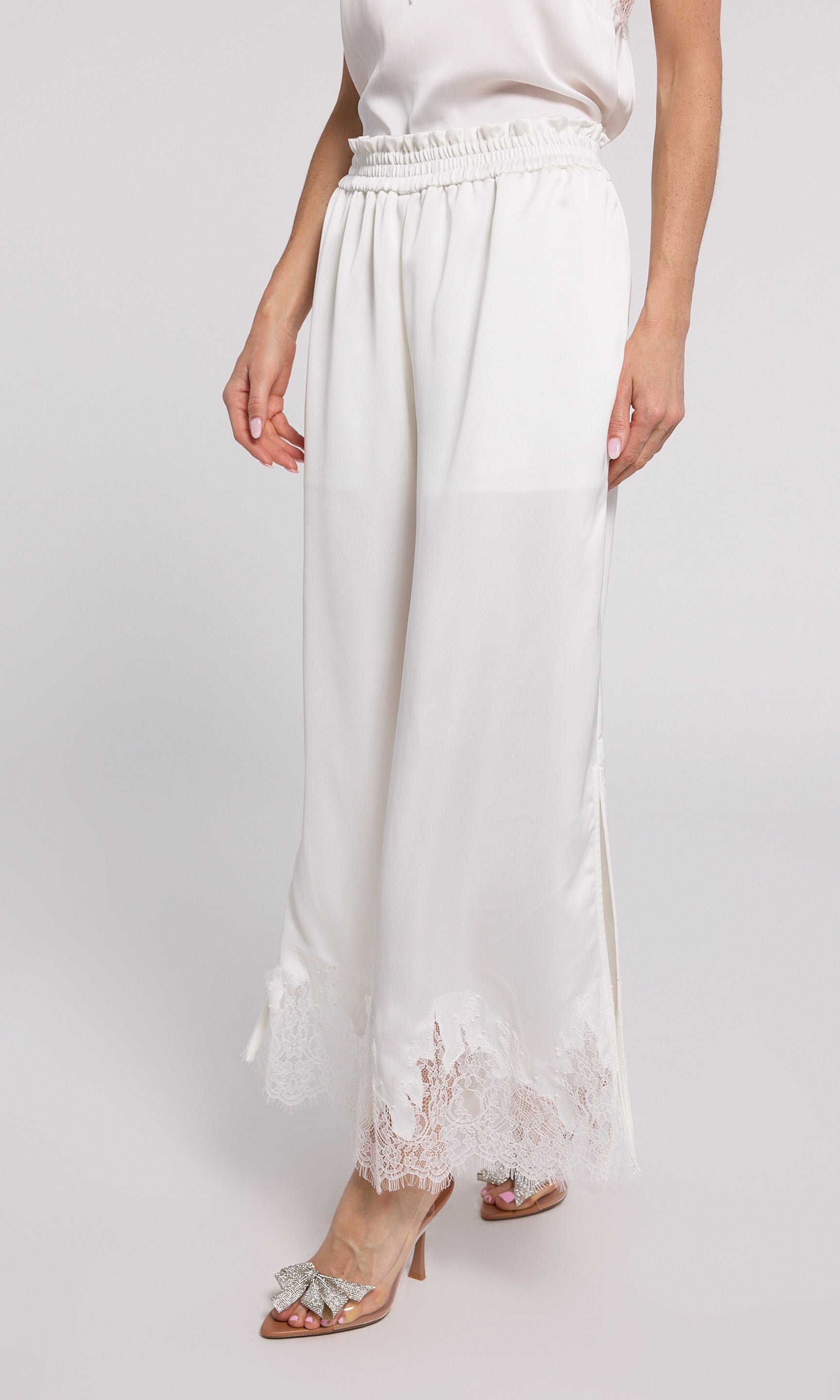 Stylish white wide-leg pants with delicate lace trim, perfect for adding a touch of elegance to your outfit.