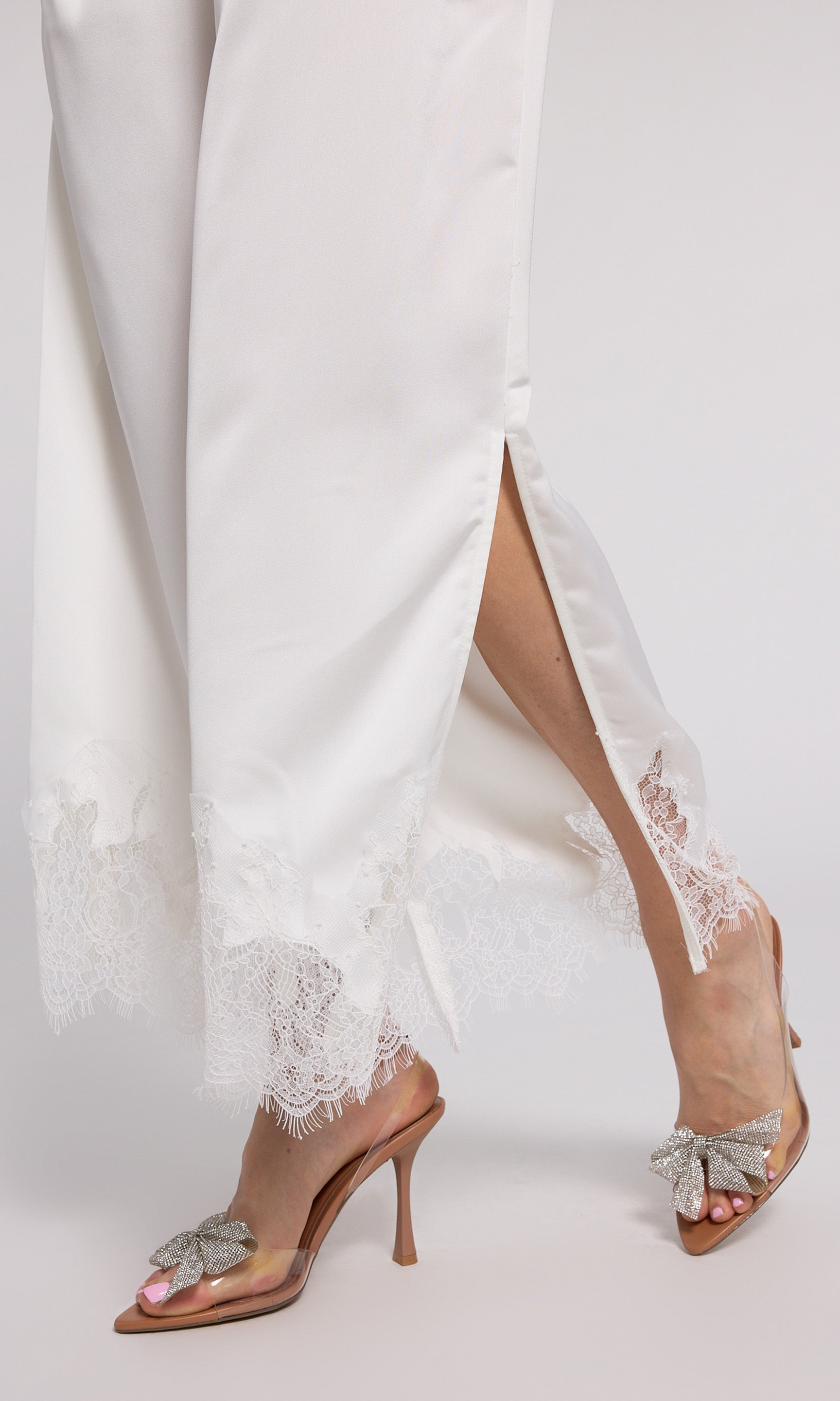 Stylish white wide-leg pants with delicate lace trim, perfect for adding a touch of elegance to your outfit.