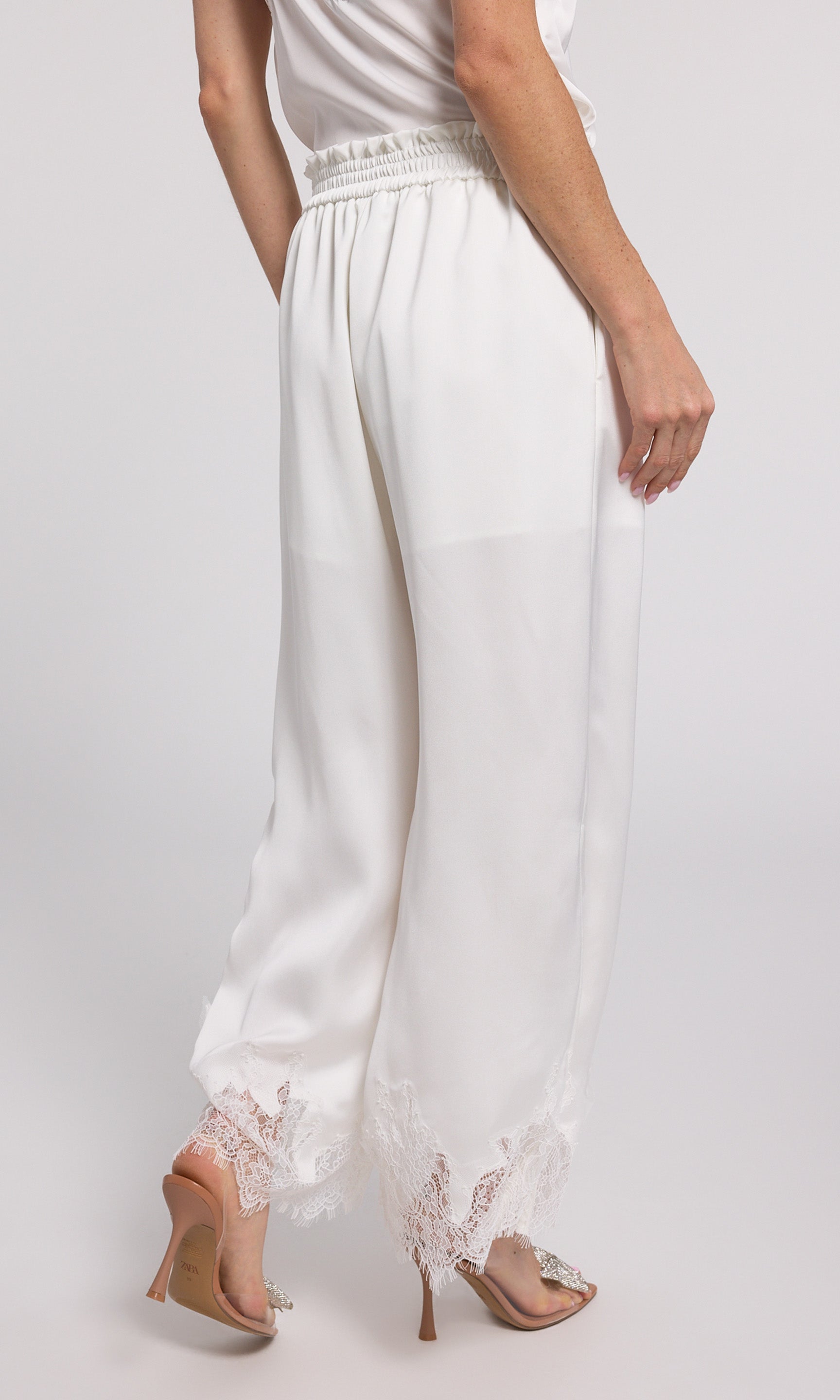 Stylish white wide-leg pants with delicate lace trim, perfect for adding a touch of elegance to your outfit.