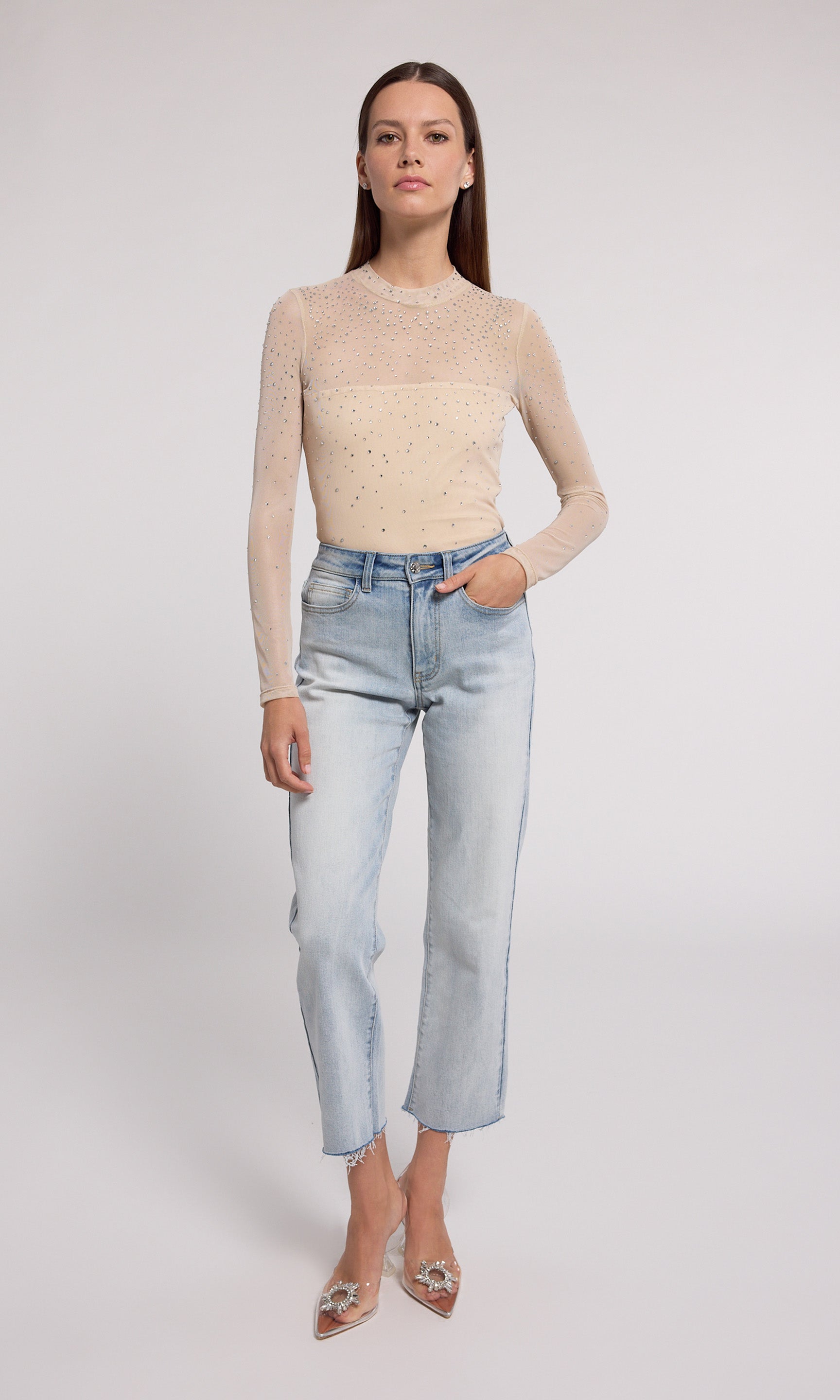 A nude mesh bodysuit adorned with shimmering silver dots, showcasing a stylish and elegant design.