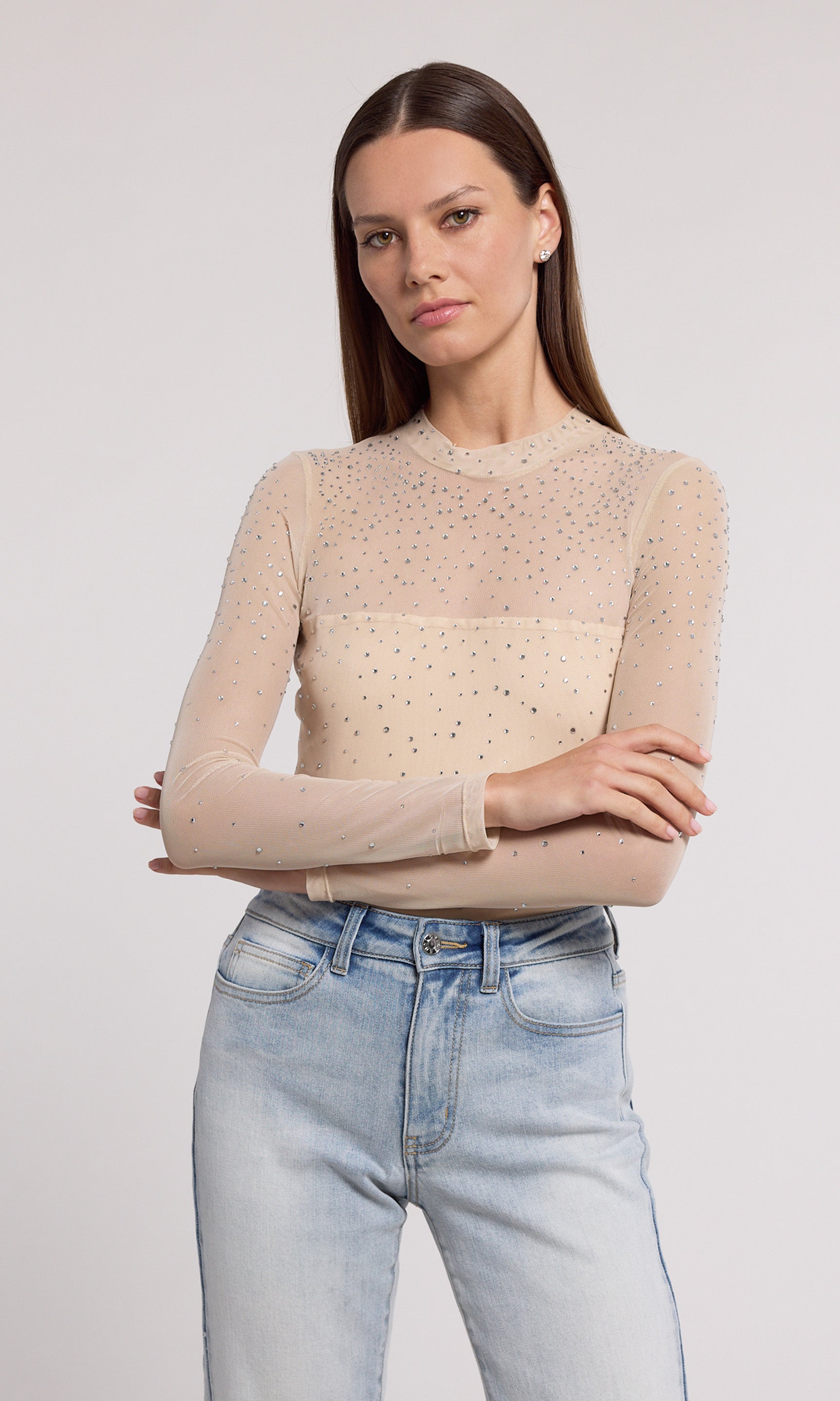 A nude mesh bodysuit adorned with shimmering silver dots, showcasing a stylish and elegant design.