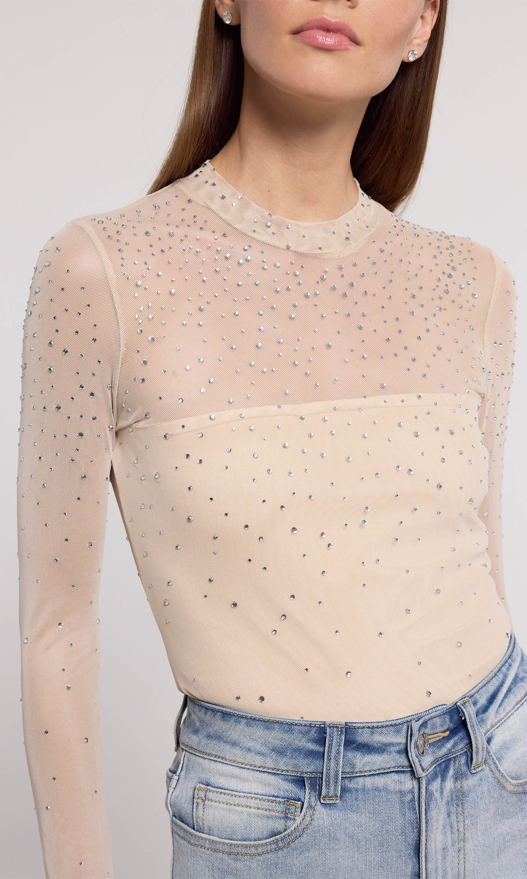 A nude mesh bodysuit adorned with shimmering silver dots, showcasing a stylish and elegant design.