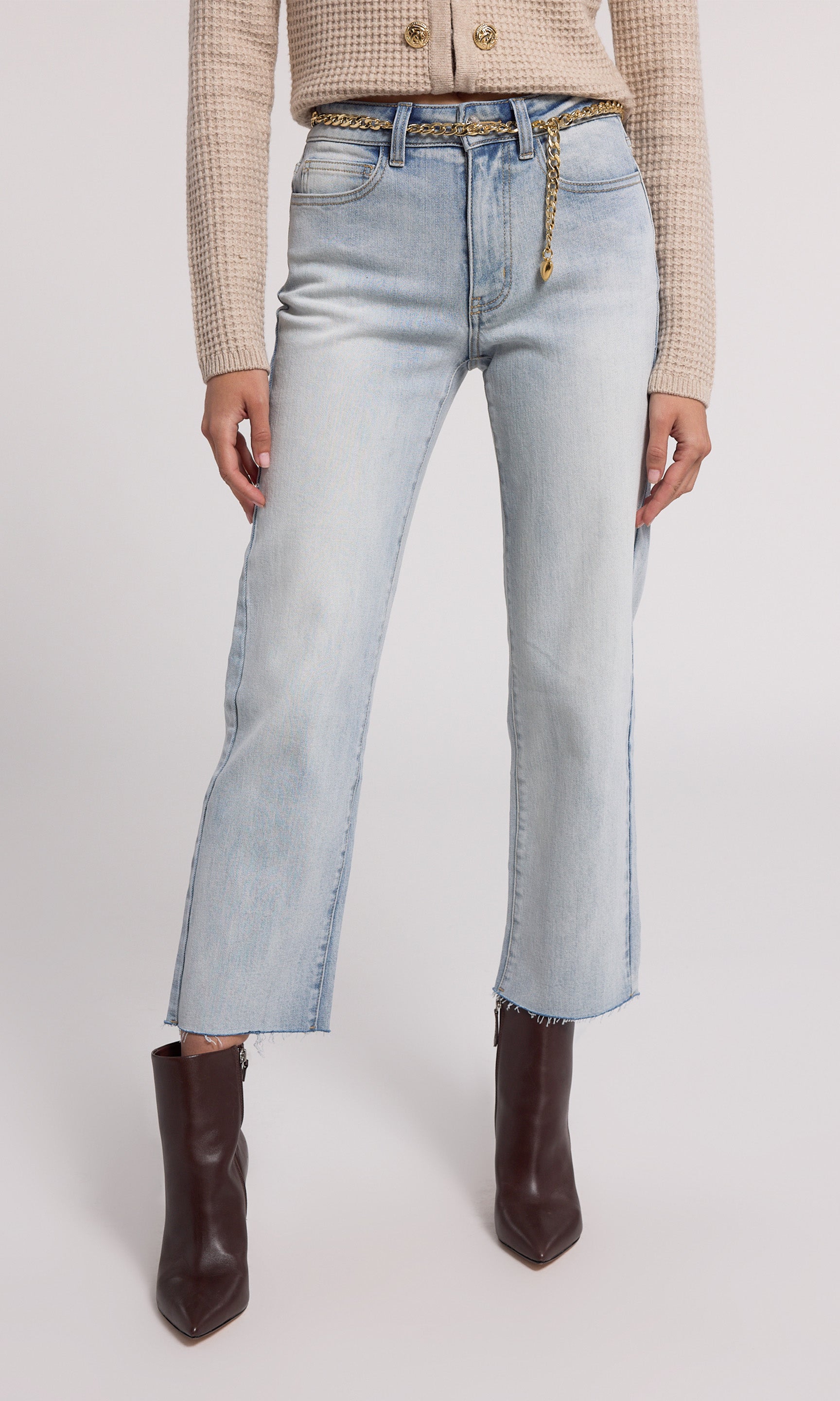 A pair of light blue denim Jordy chain belt jeans with a straight leg cut and high-rise waist. The jeans feature a removable belt with a gold-tone chain.