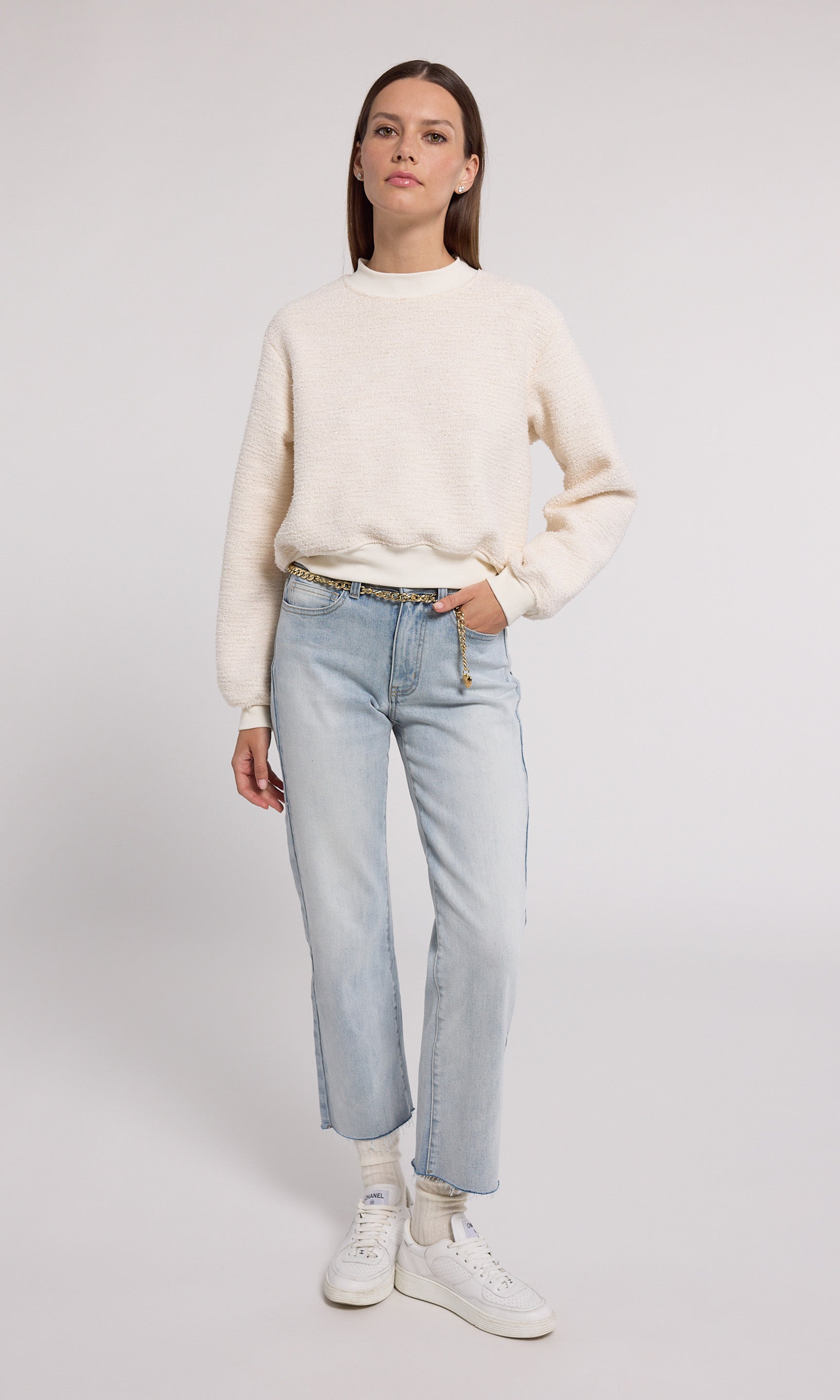 A cream sweatshirt crafted from soft knit fabric, showcasing a comfortable and stylish design suitable for various occasions.
