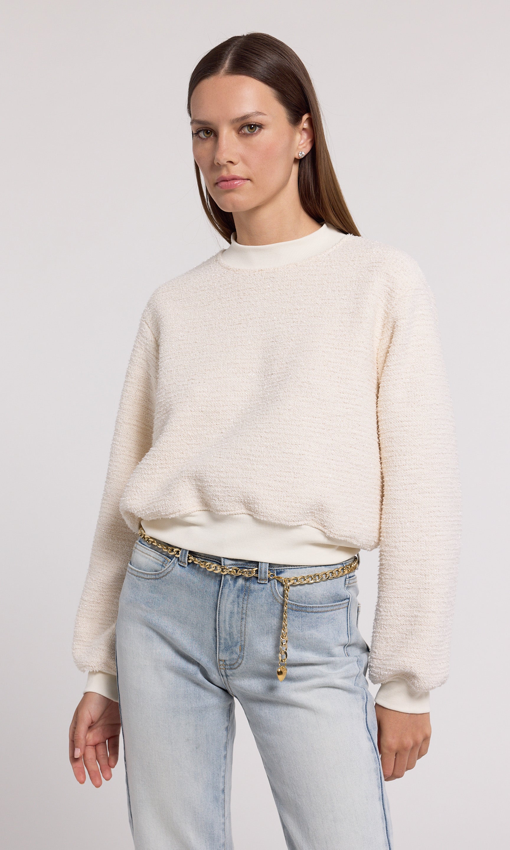 A cream sweatshirt crafted from soft knit fabric, showcasing a comfortable and stylish design suitable for various occasions.