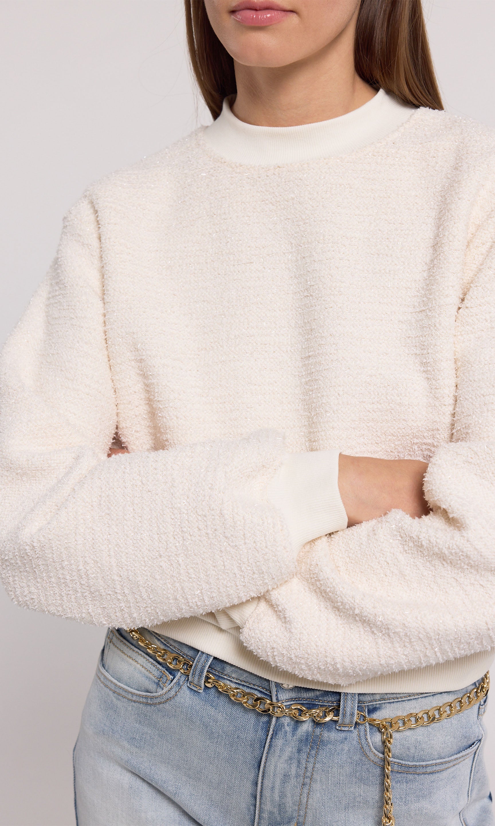 A cream sweatshirt crafted from soft knit fabric, showcasing a comfortable and stylish design suitable for various occasions.