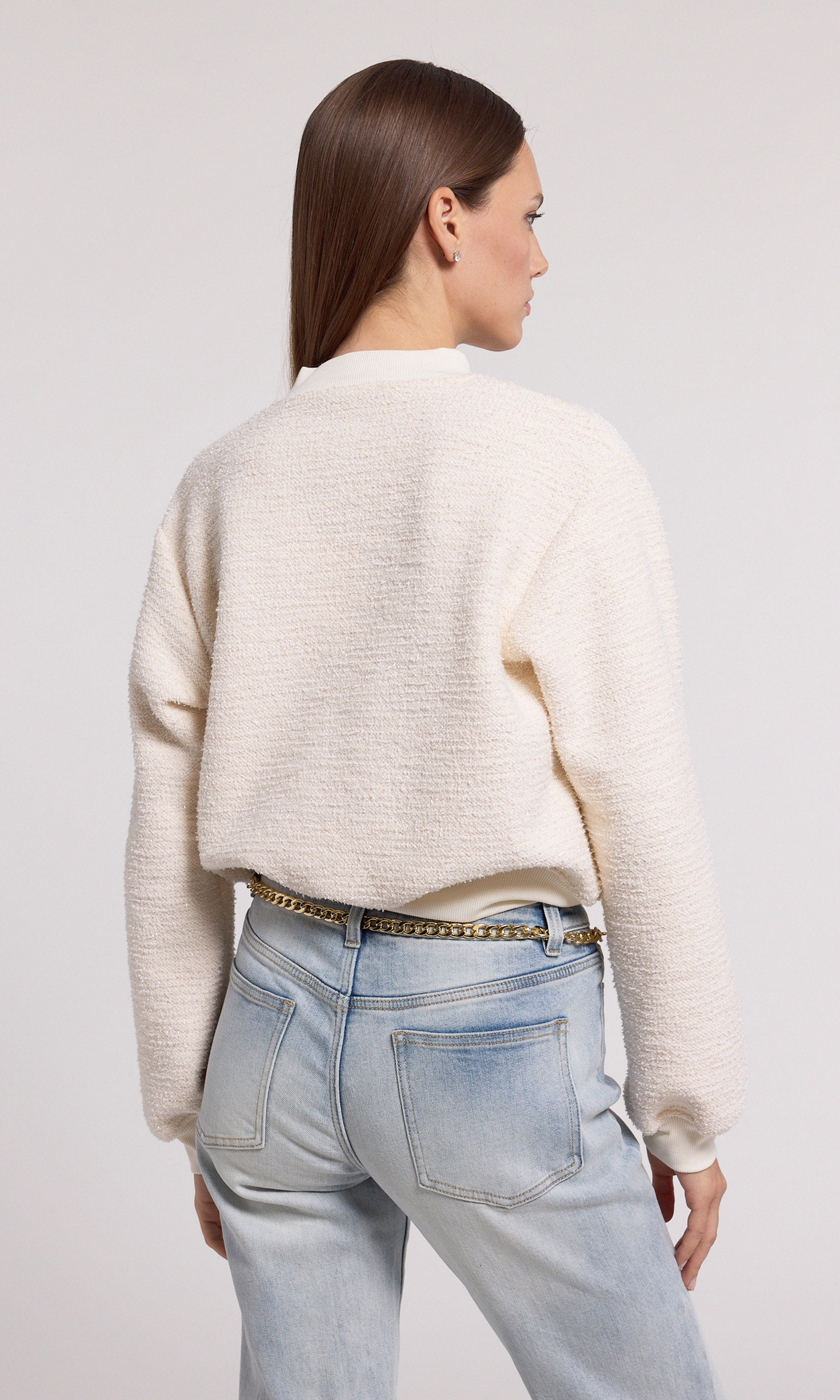 A cream sweatshirt crafted from soft knit fabric, showcasing a comfortable and stylish design suitable for various occasions.
