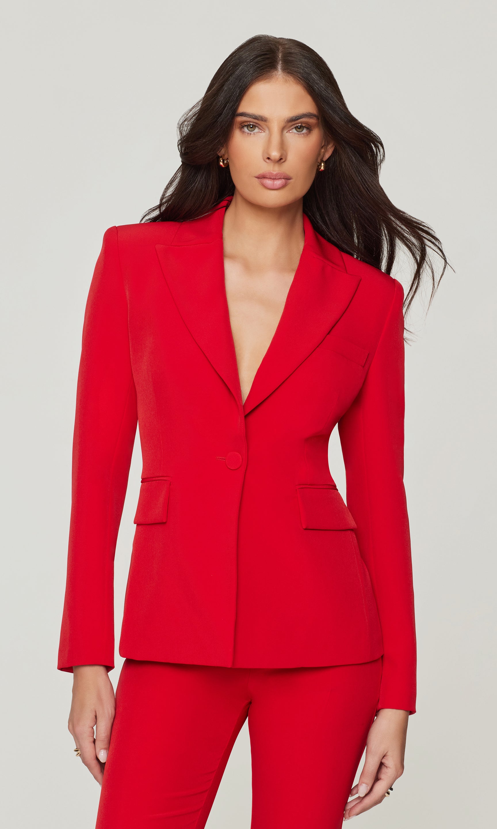 Woman wearing a red suit on a plain background