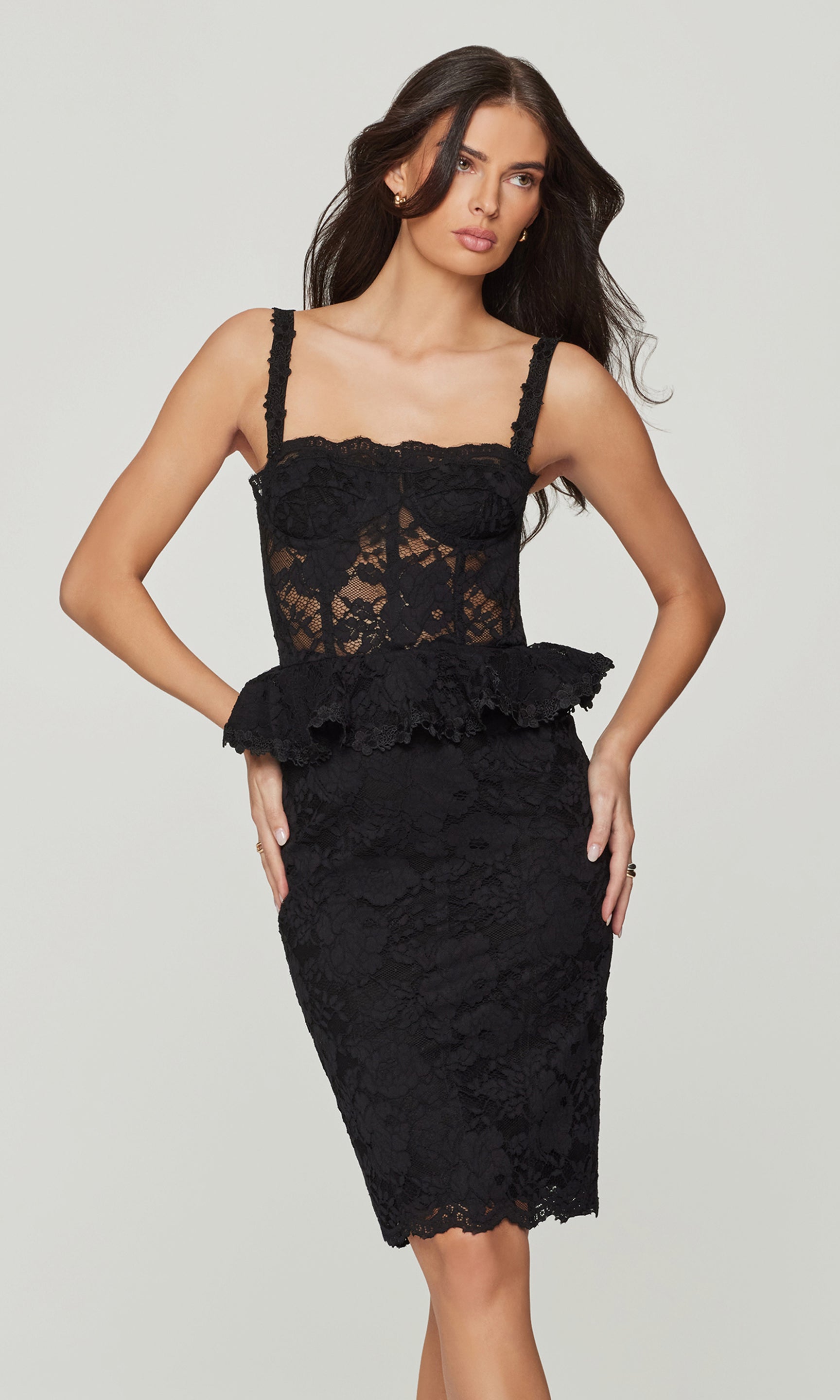 Woman wearing a black lace dress on a plain background