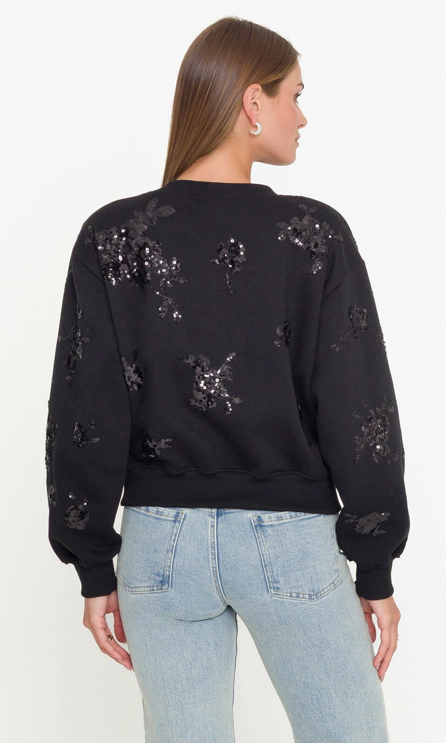 Black sequin sweatshirt worn by a person on a white background
