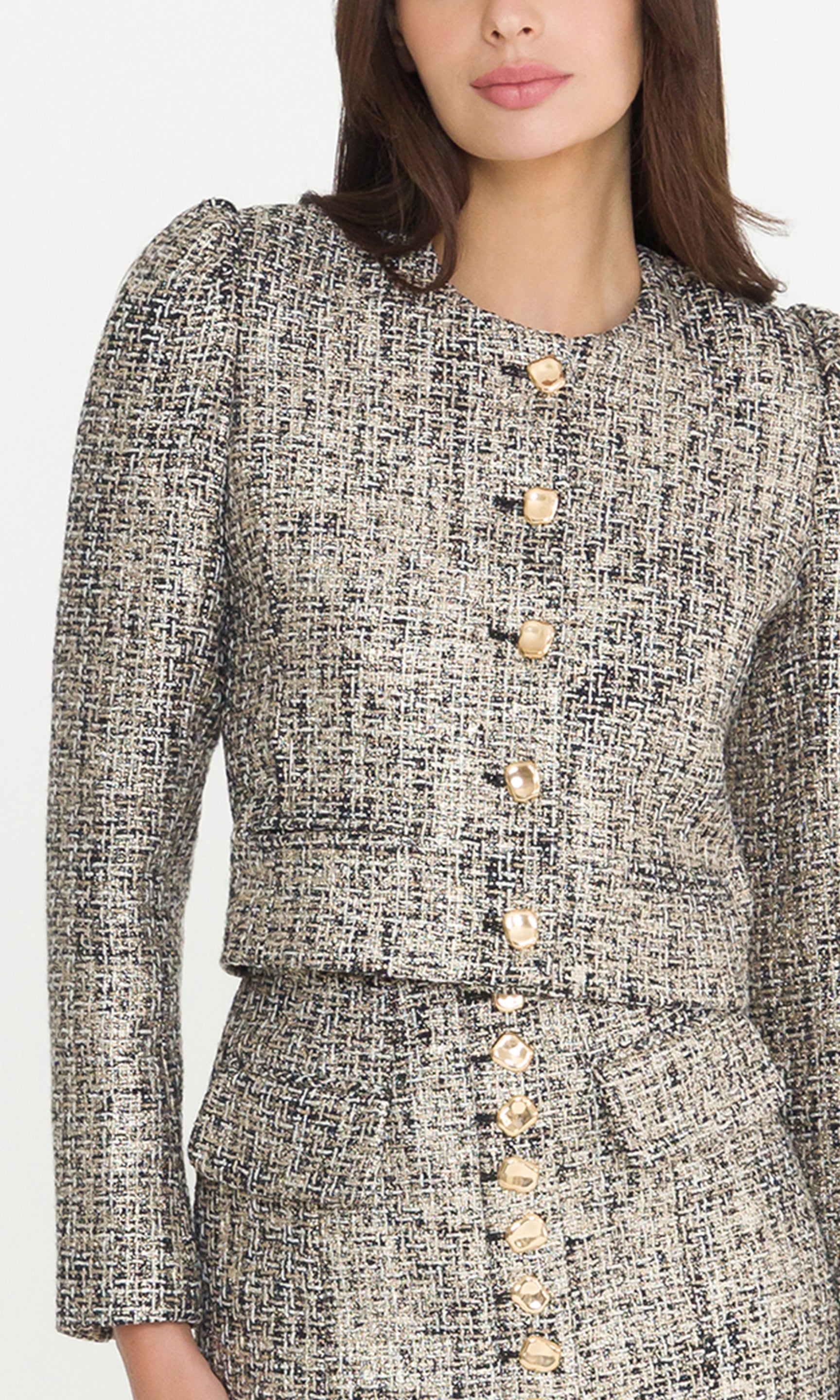 Detail image of model wearing a gold multi tweed jacket, showcasing the tweed details and gold button front