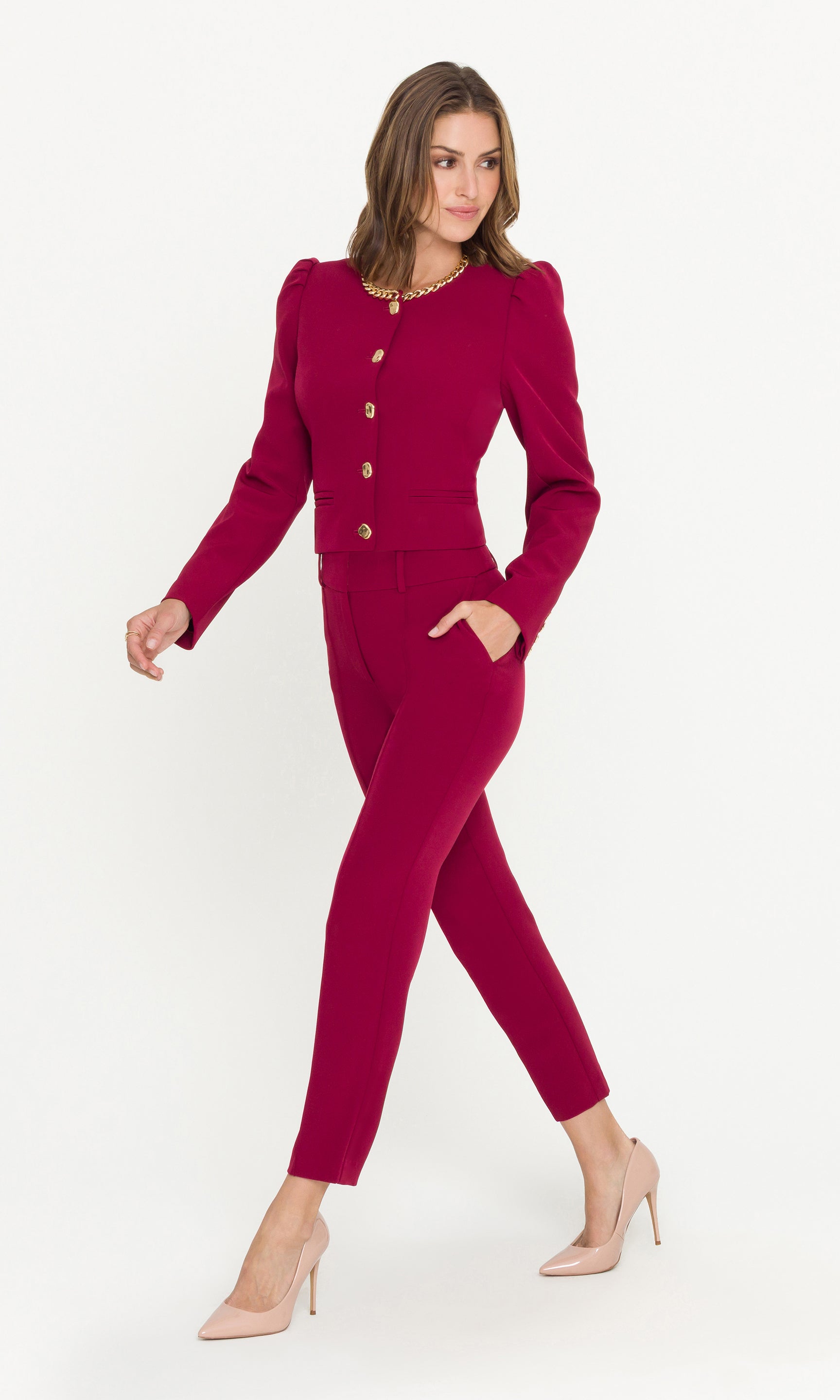 Woman wearing a magenta suit with a white background