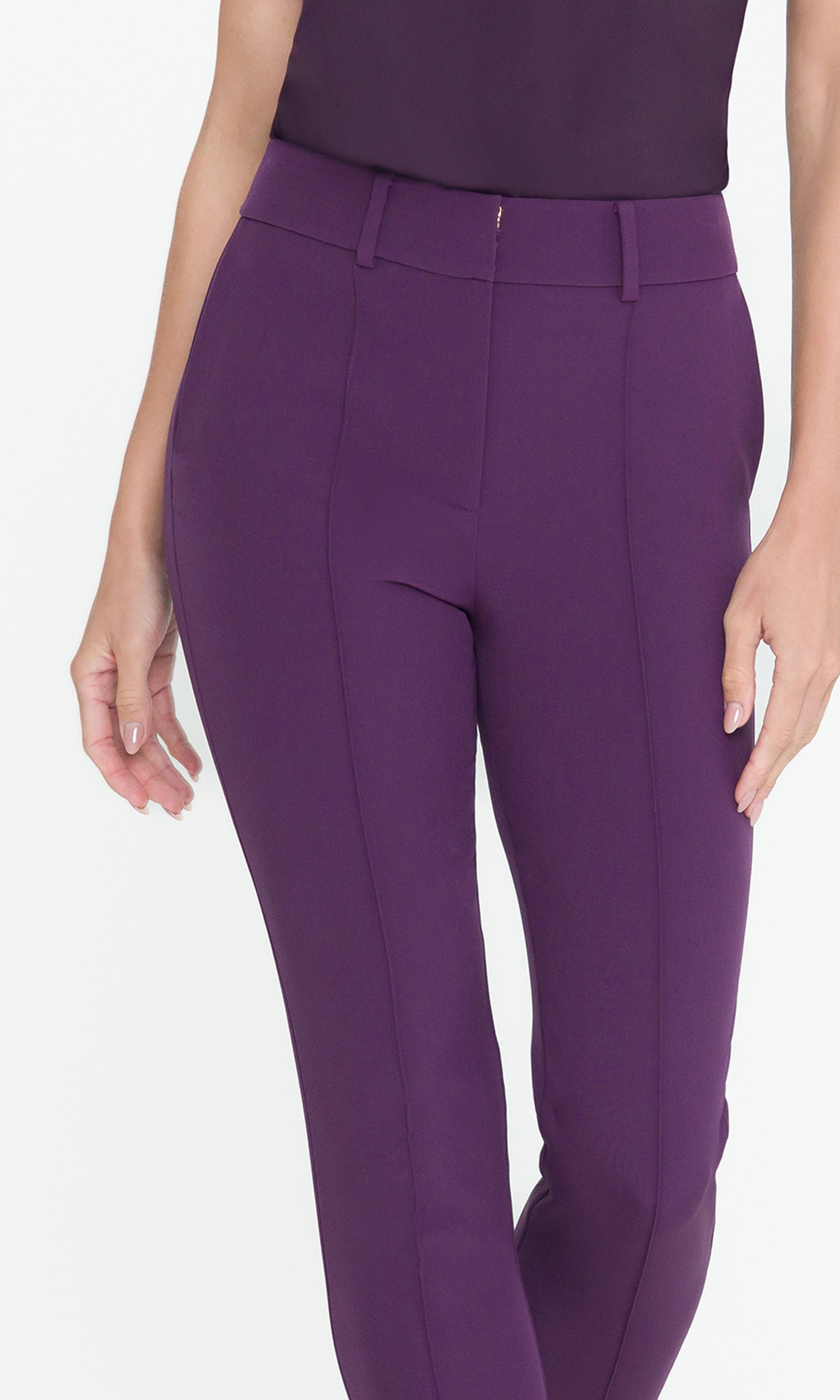 Detail shot of model wearing purple pants with a matching top, showcasing the tailored fit of the pants