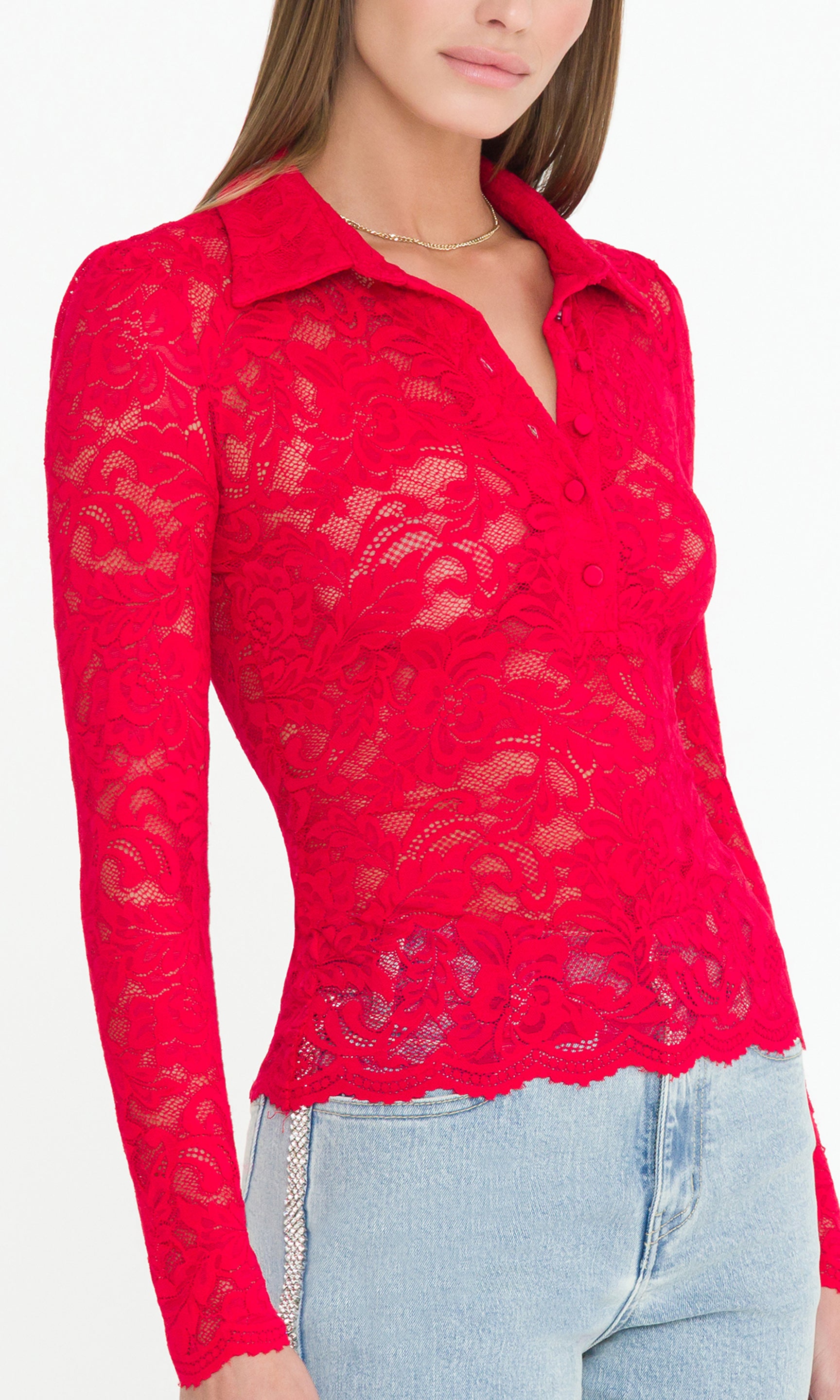 Detail image of model wearing a long sleeve red lace top, showcasing the lace detail and button collared front