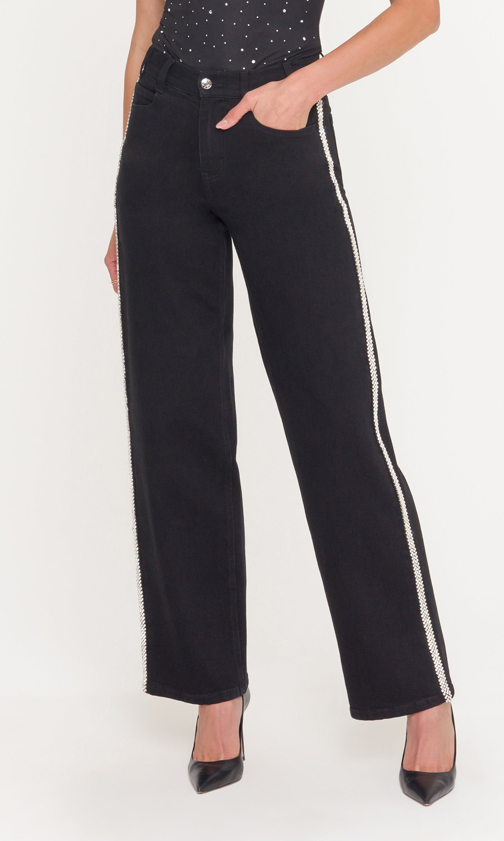 Black pants with crystals on the pant leg worn by a person on a white background