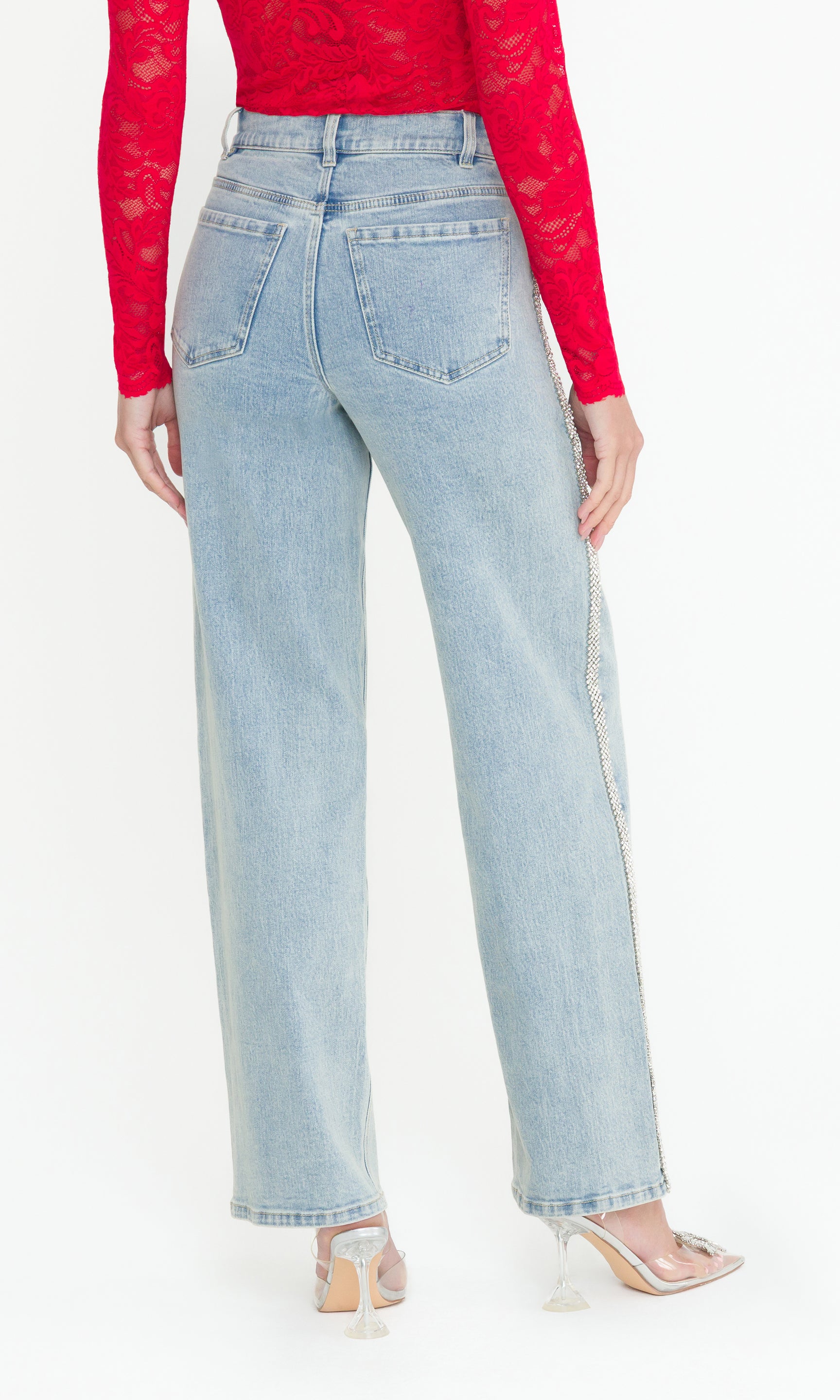 Back view of Light blue jeans worn by a person with a red top on a white background