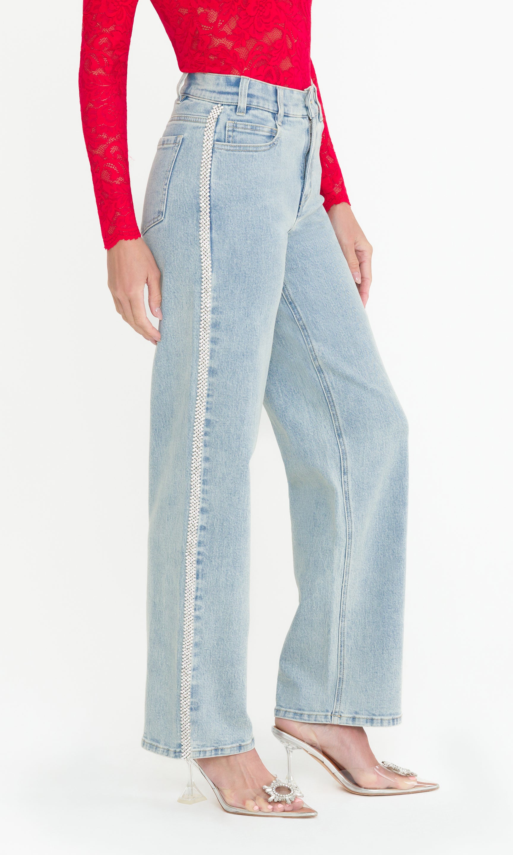 Side view of Light blue jeans worn by a person on a white background, showcasing the crystal embellishments