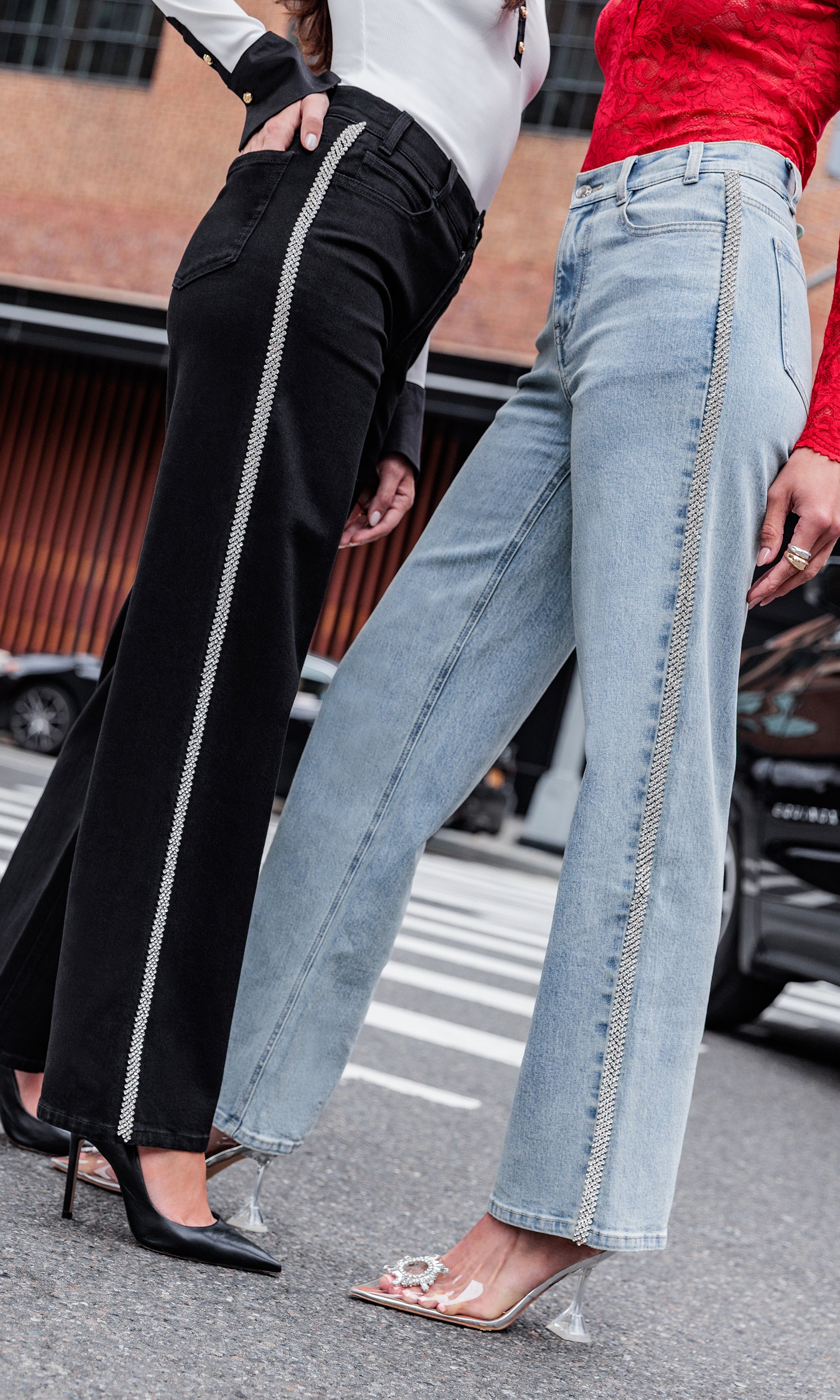 Two pairs of pants, one black and one light blue, being worn on a street.