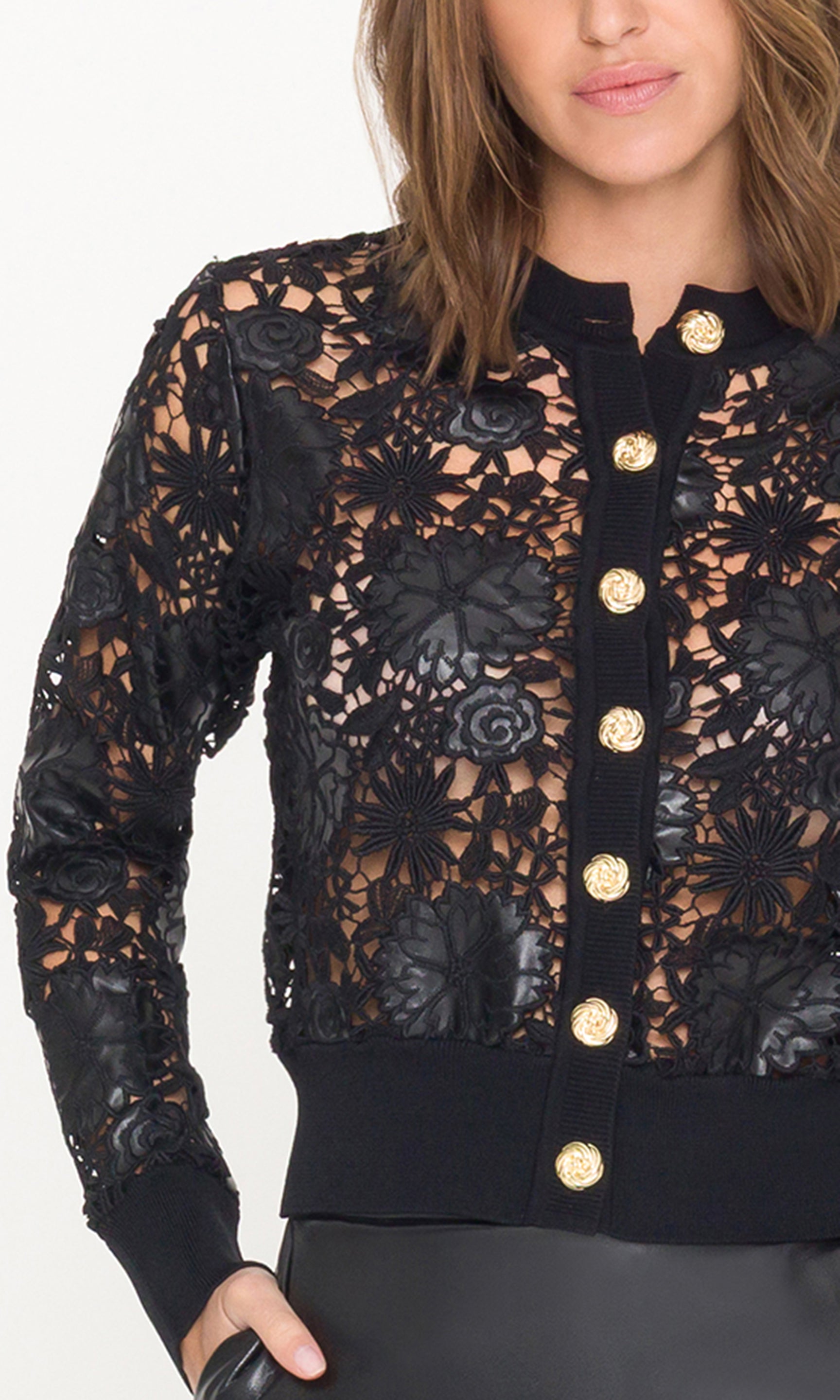 Black lace cardigan with gold buttons worn by a person on a white background