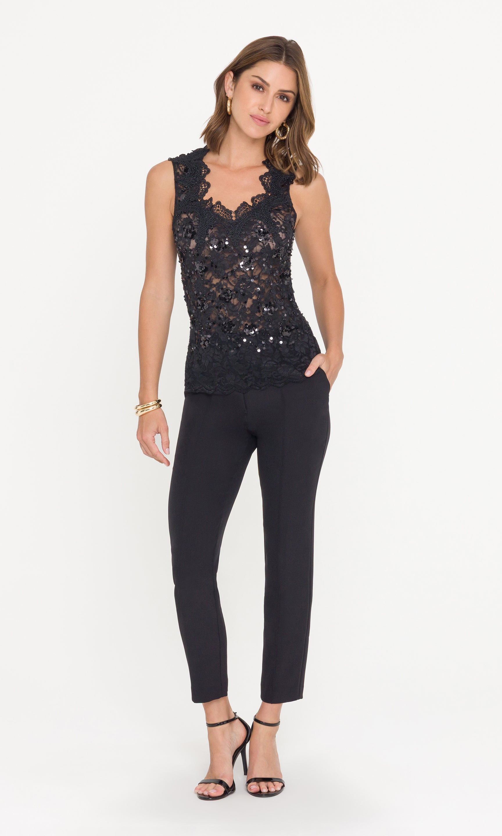 Full body image of model wearing a black sequin top and black pants on a white background