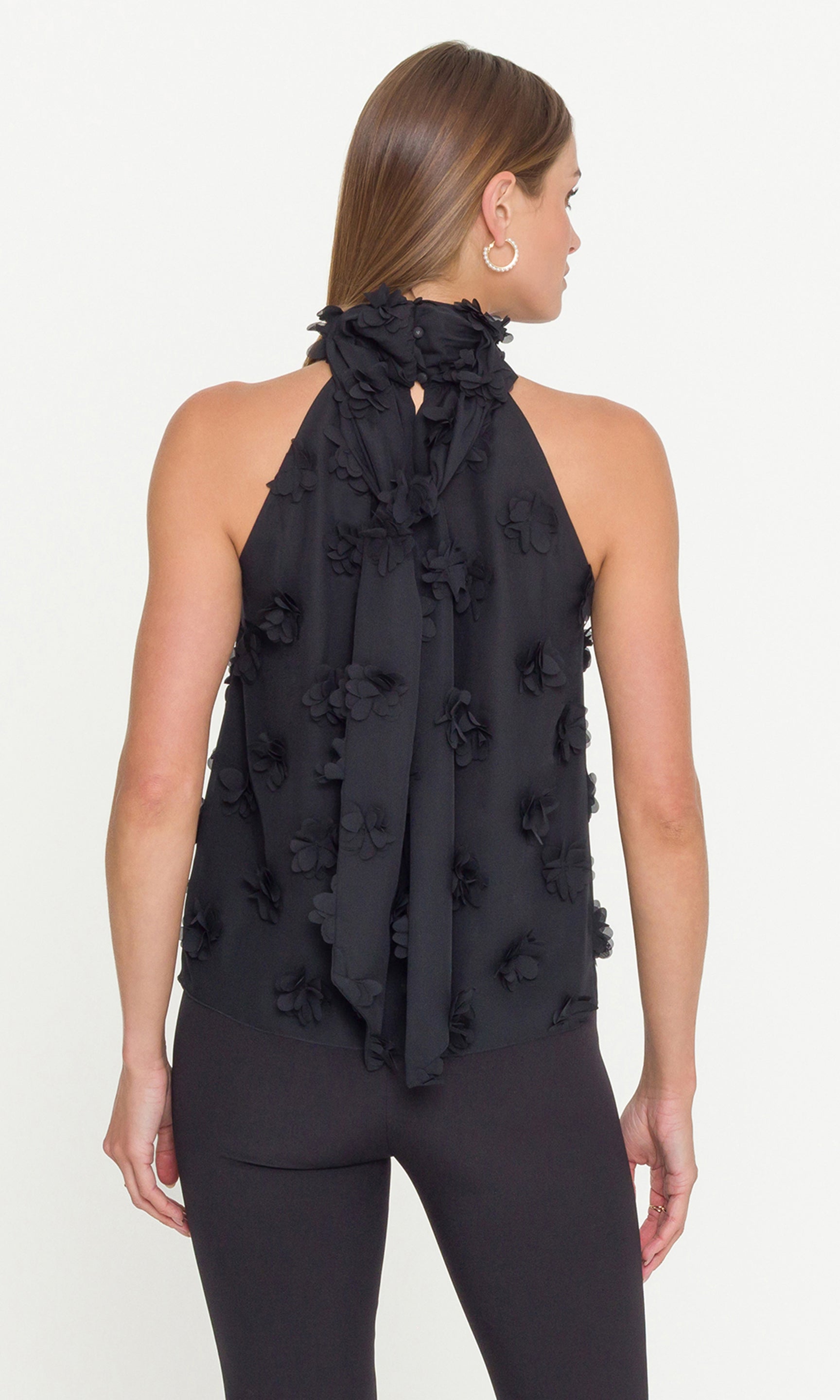 Black halter top with floral details on a white background