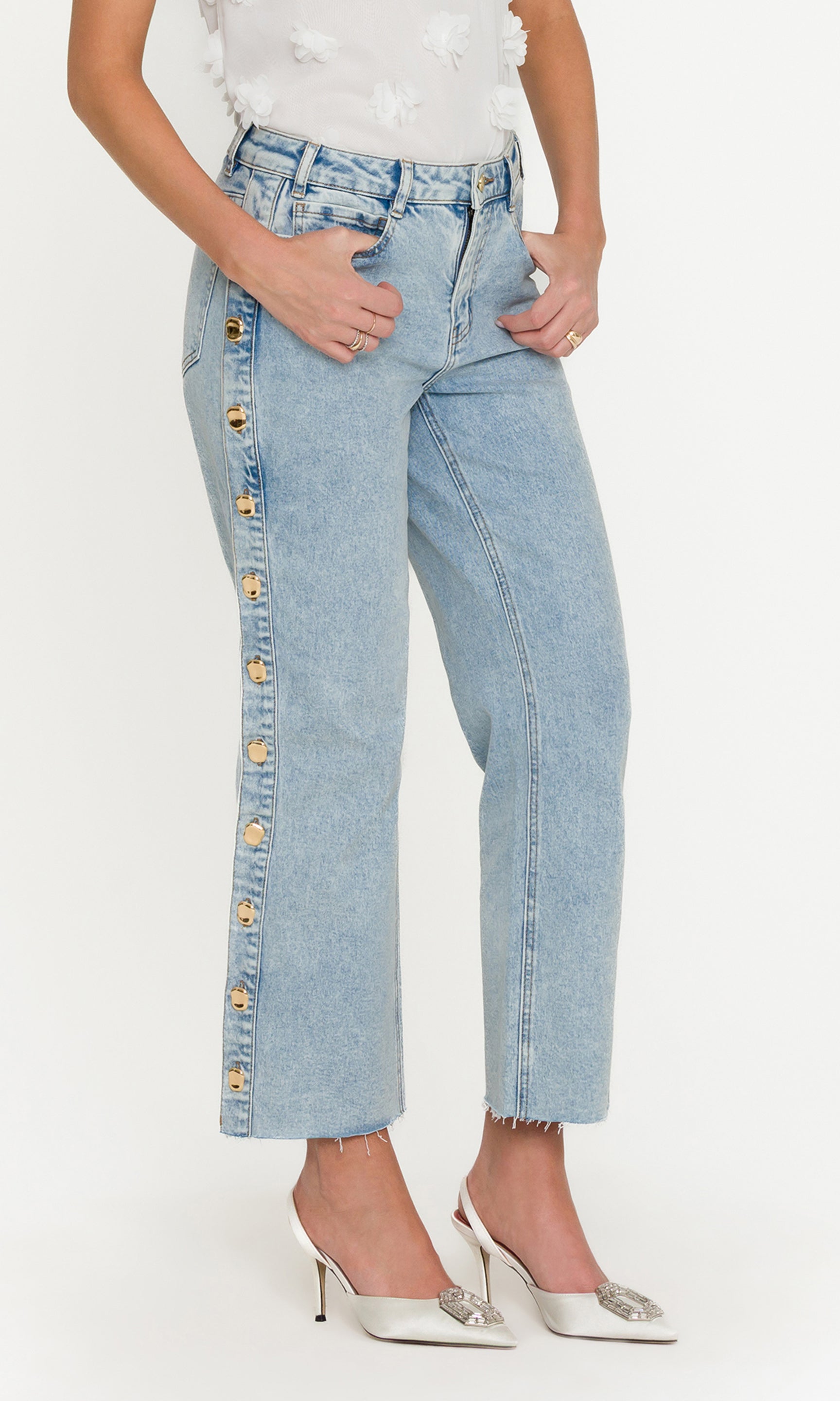 Light blue jeans with button details on a white background