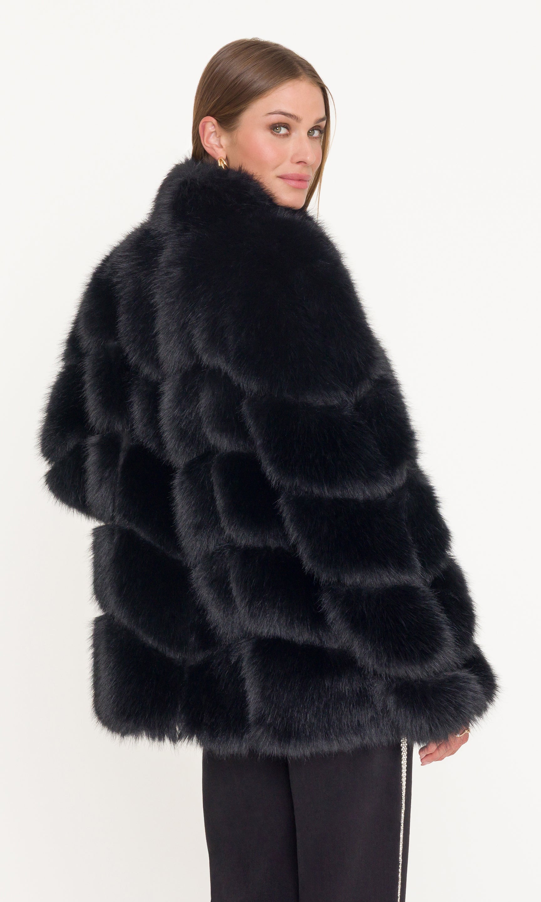 Back view image of woman wearing a black fur coat on a white background