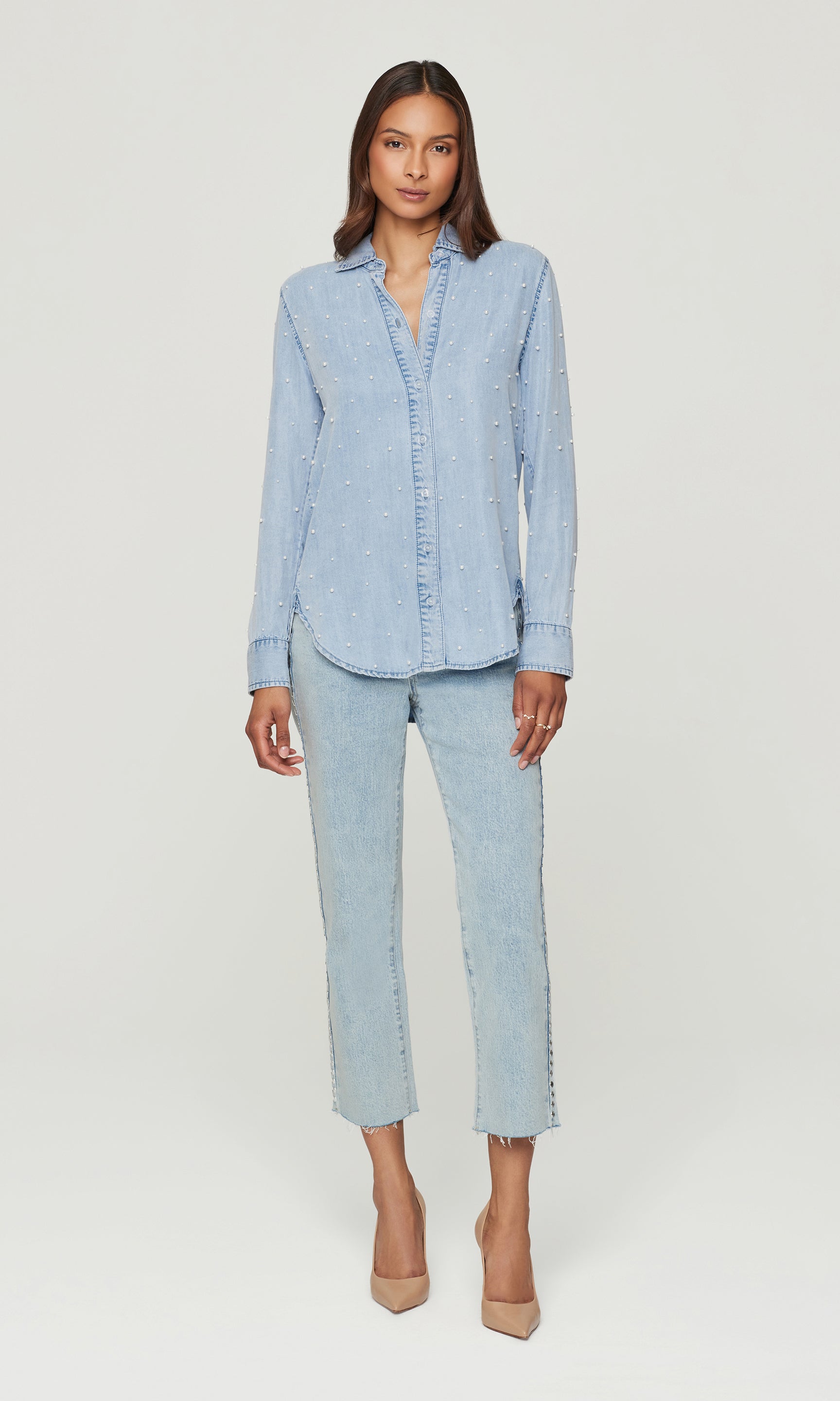 Woman wearing a light blue denim outfit on a white background