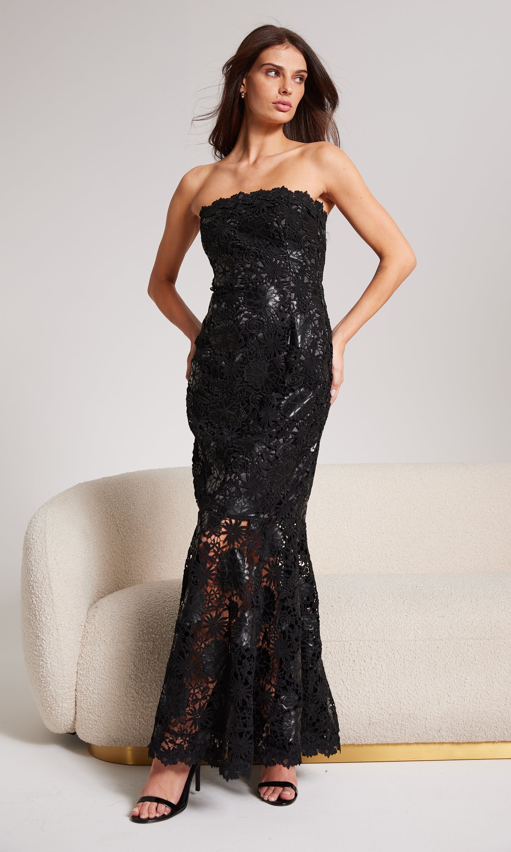 Woman wearing a black strapless sequin gown against a neutral background