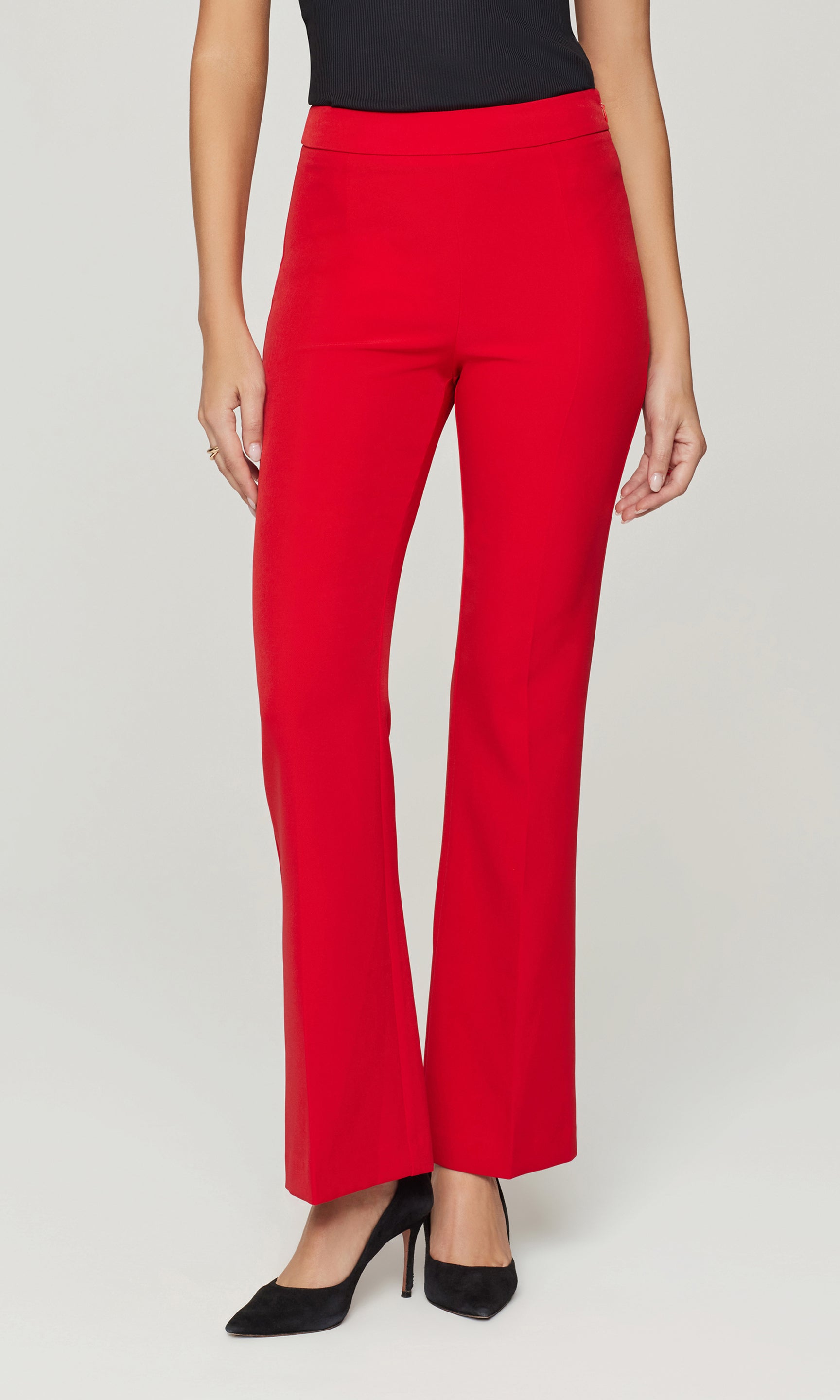 Red pants worn by a person on a white background