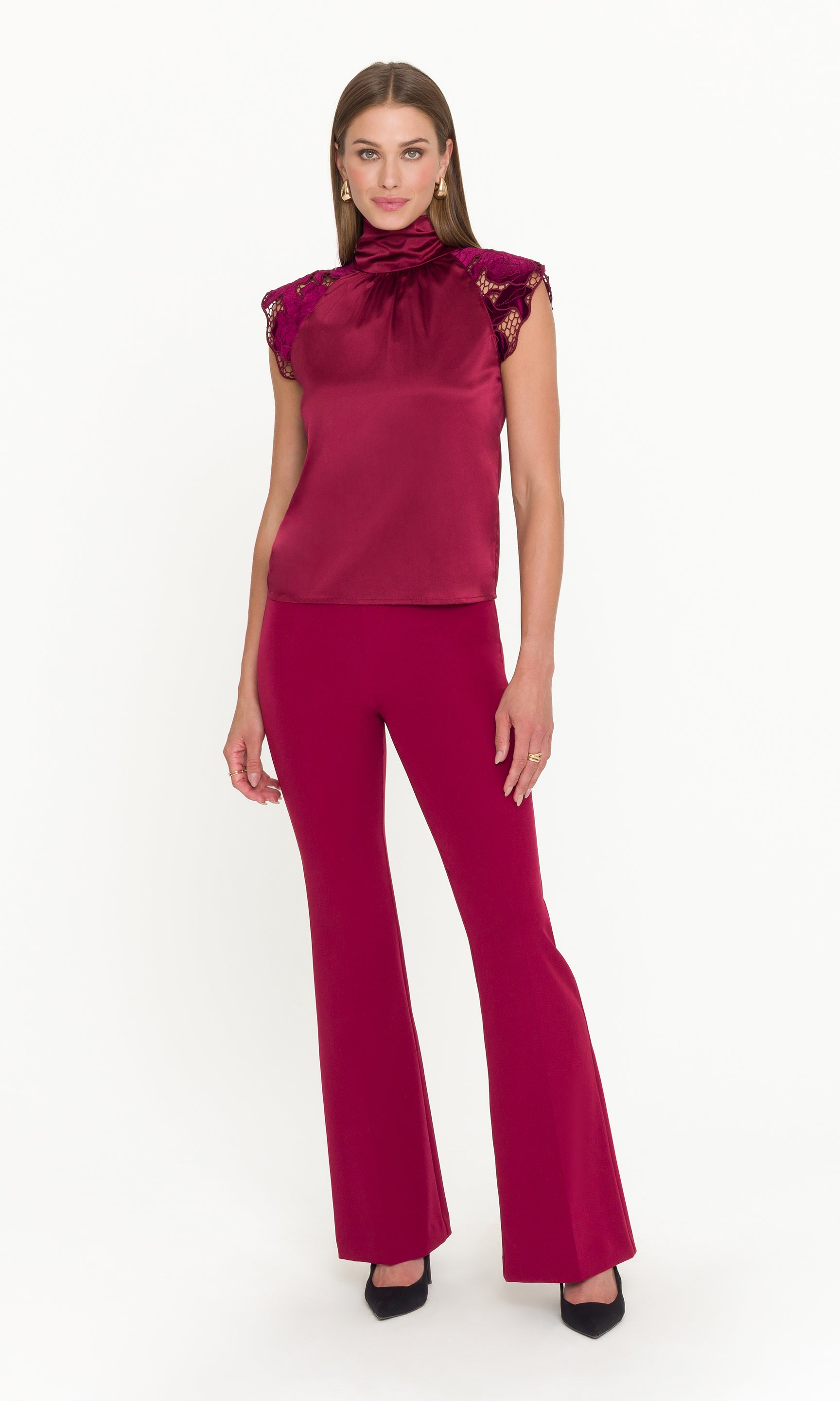 Woman wearing a burgundy outfit with a top and flared pants on a white background
