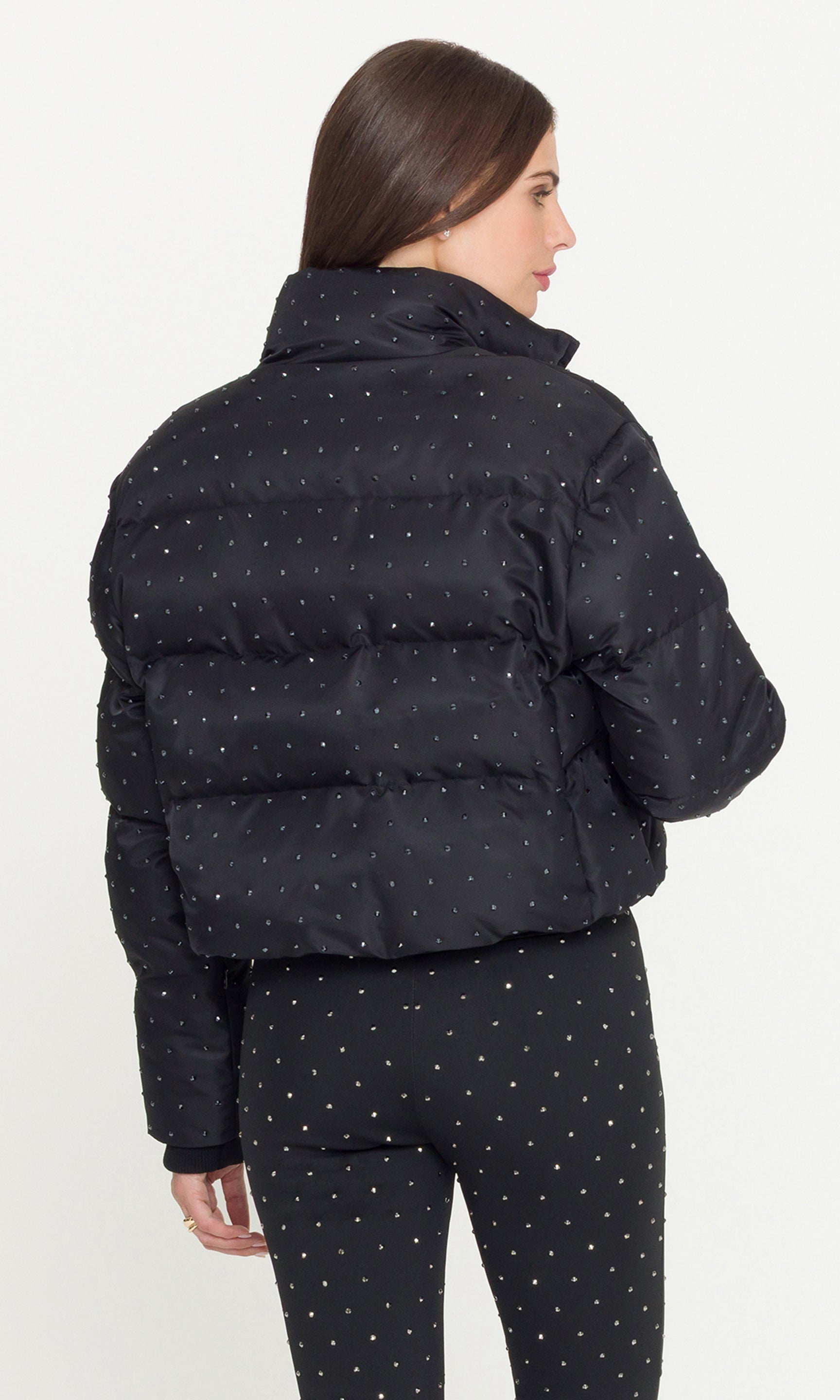 Back view of odel wearing a black crystal embellished puffer and pants