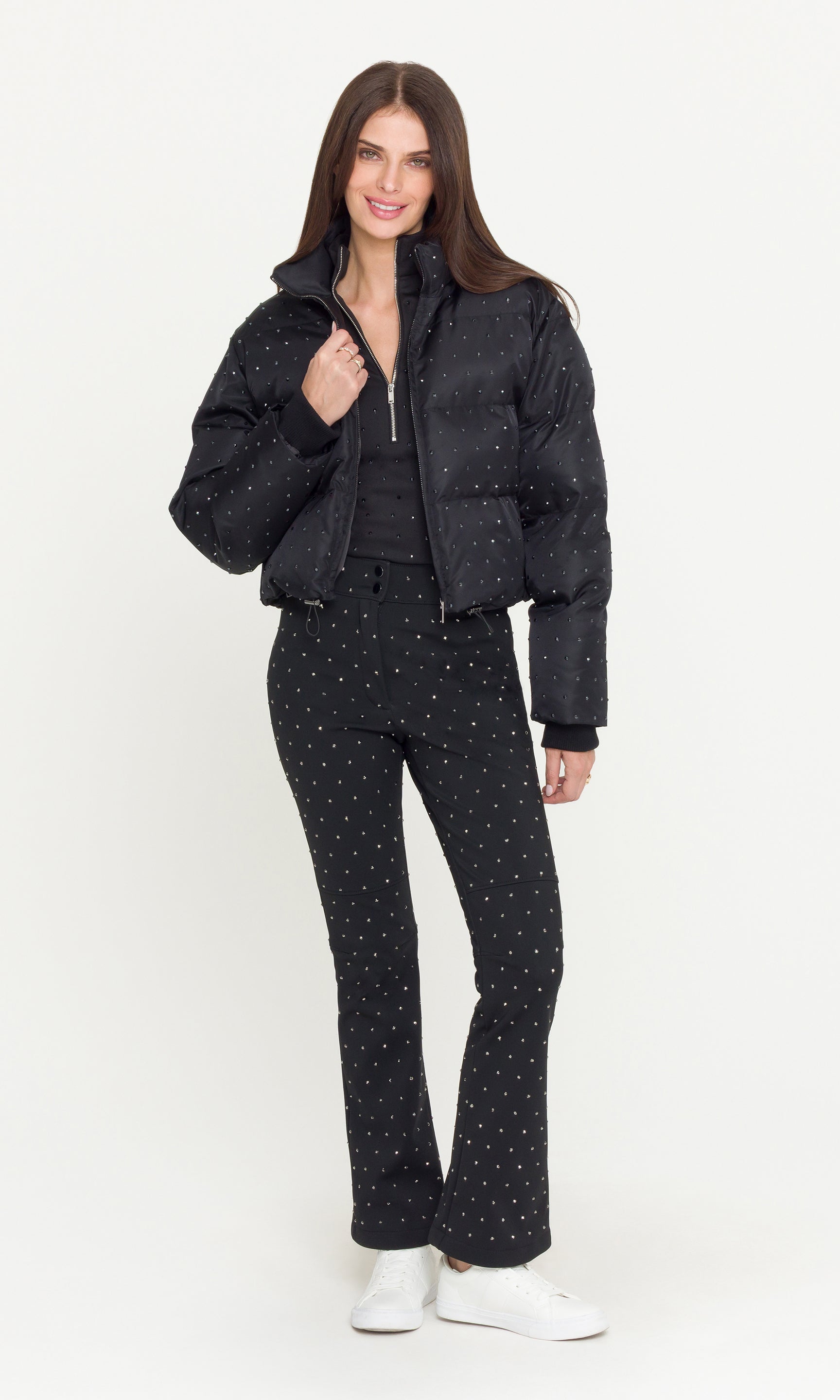 full body image of Model wearing a black crystal embellished puffer over a matching black jacket and pants