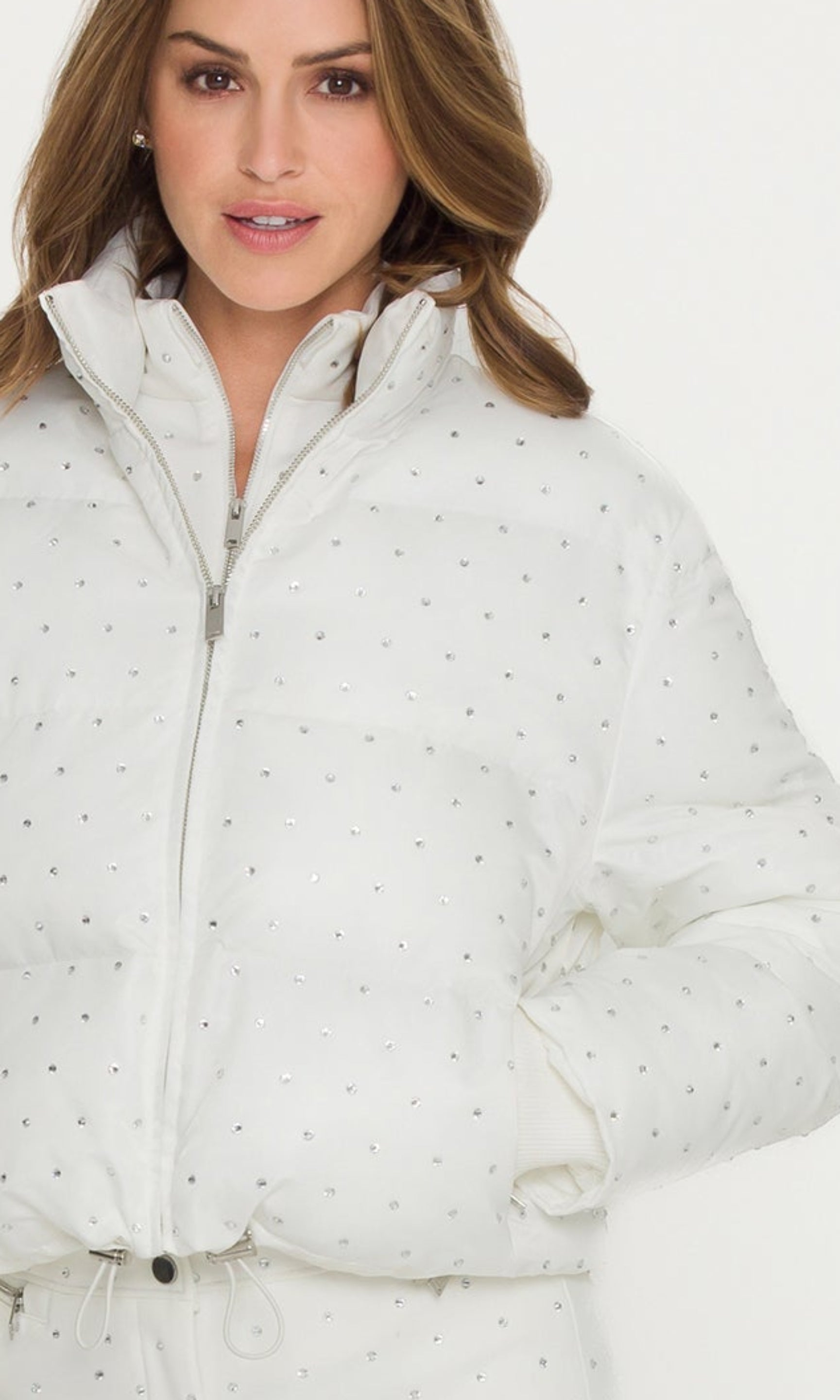 Woman wearing a white puffer jacket and pants on a white background