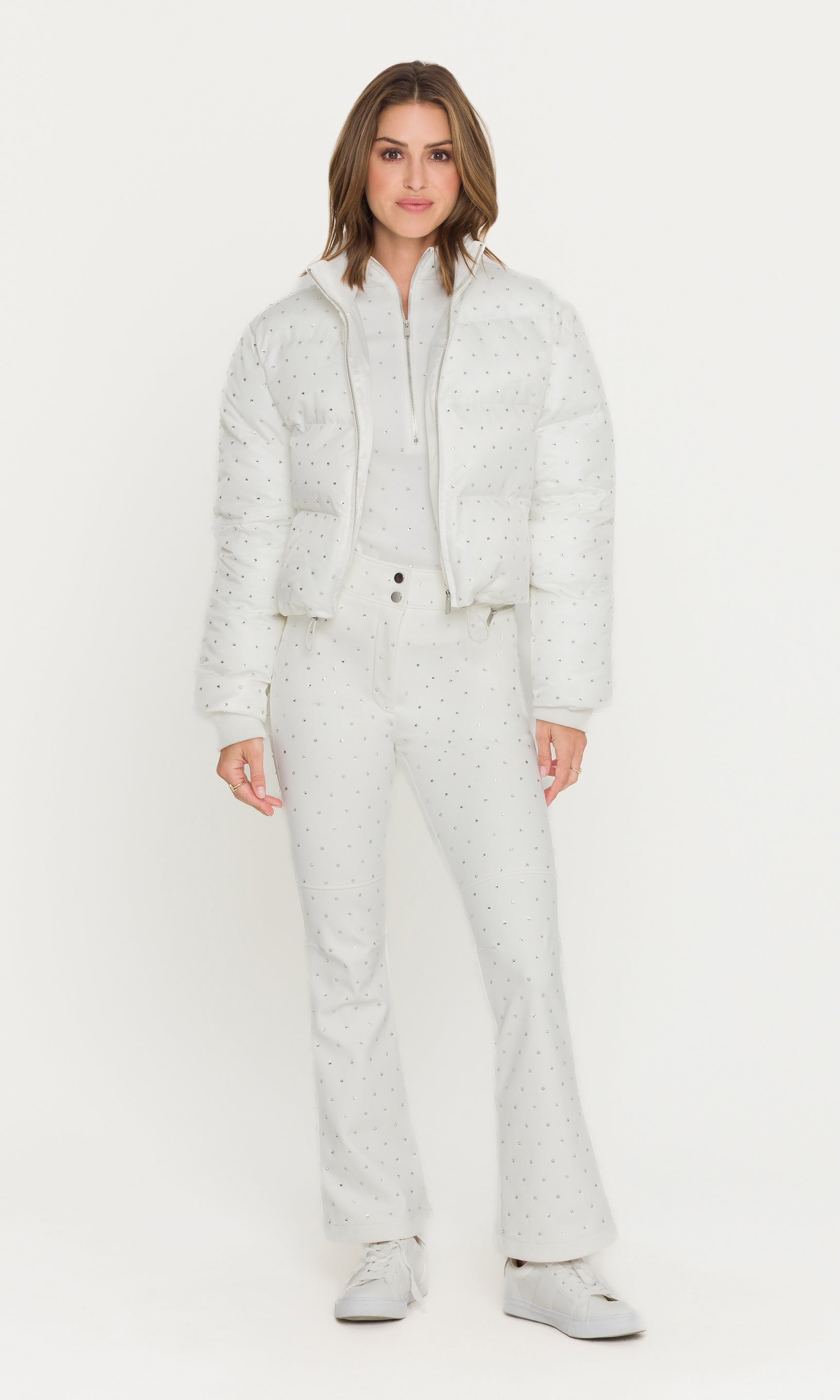 Woman wearing a white textured snowsuit on a white background