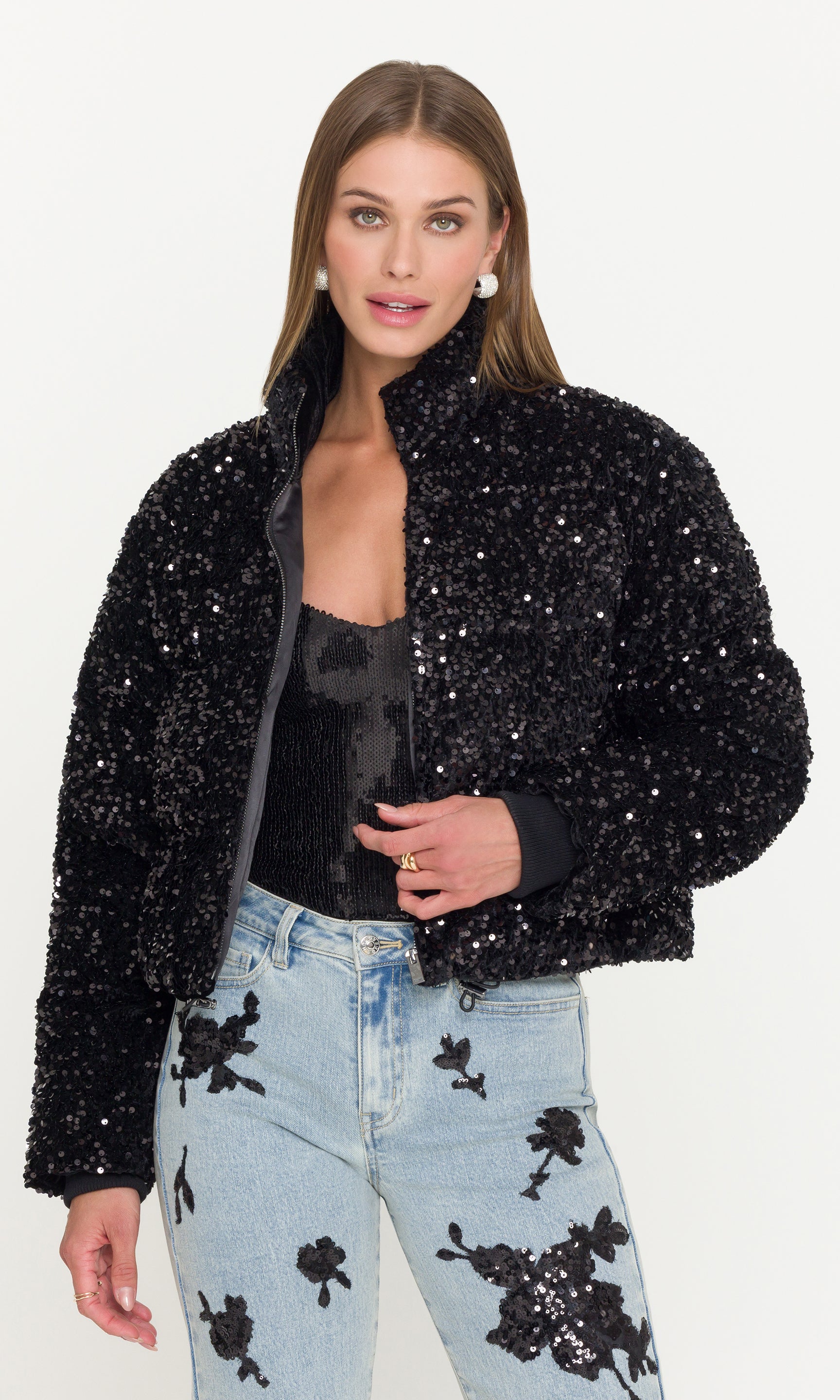 Woman wearing a black sequin jacket on a white background