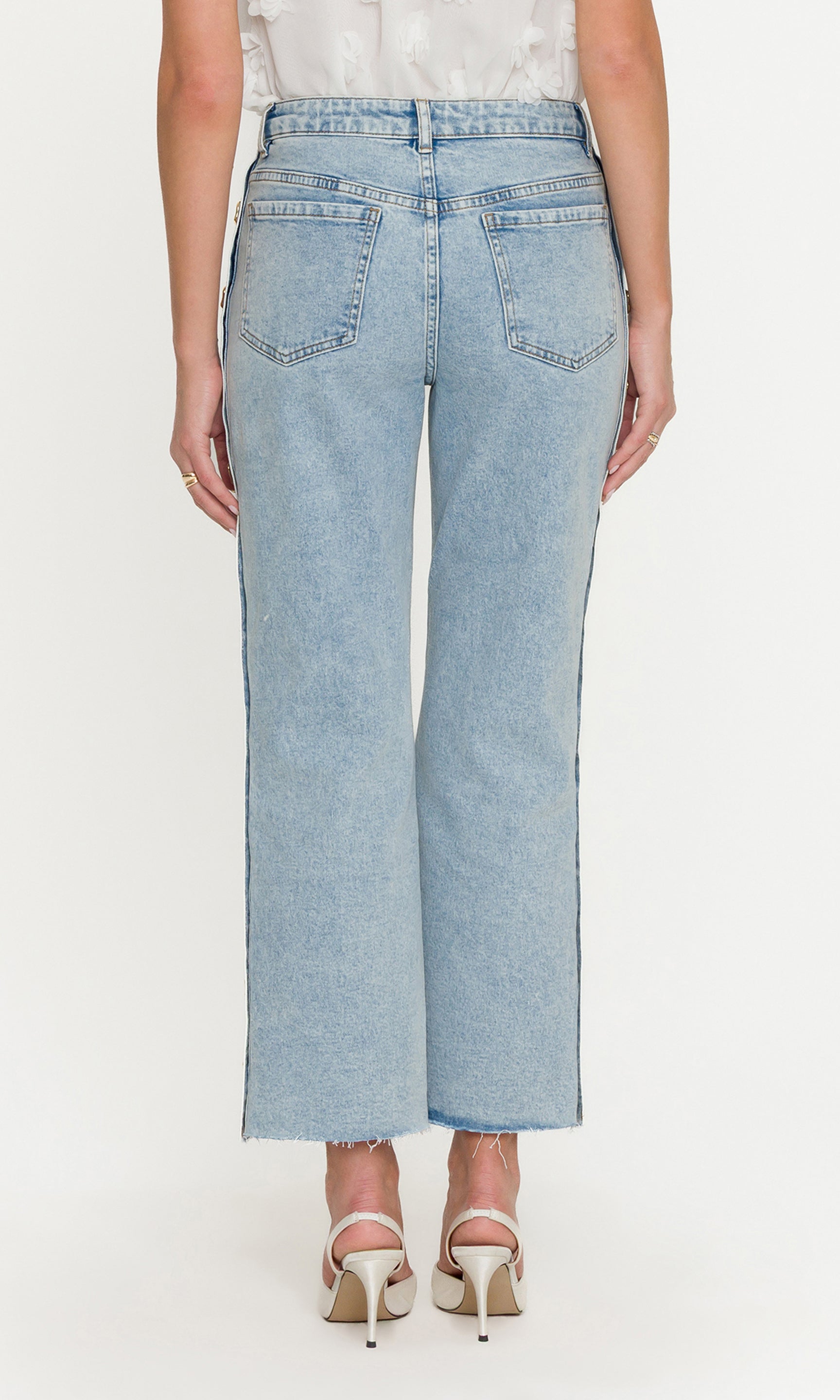 Light blue jeans worn by a person on a white background